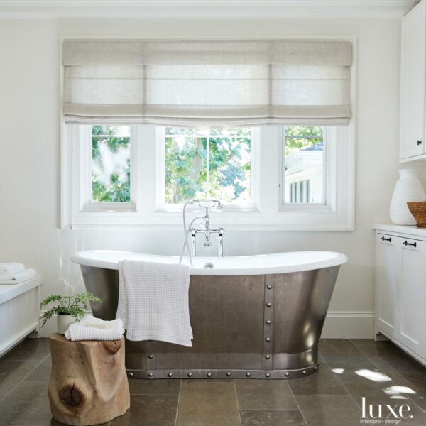 A California Wine Country Farmhouse Goes Industrial With Nods To Its Victorian Architecture The master bathroom has a large, silver-sided tub.