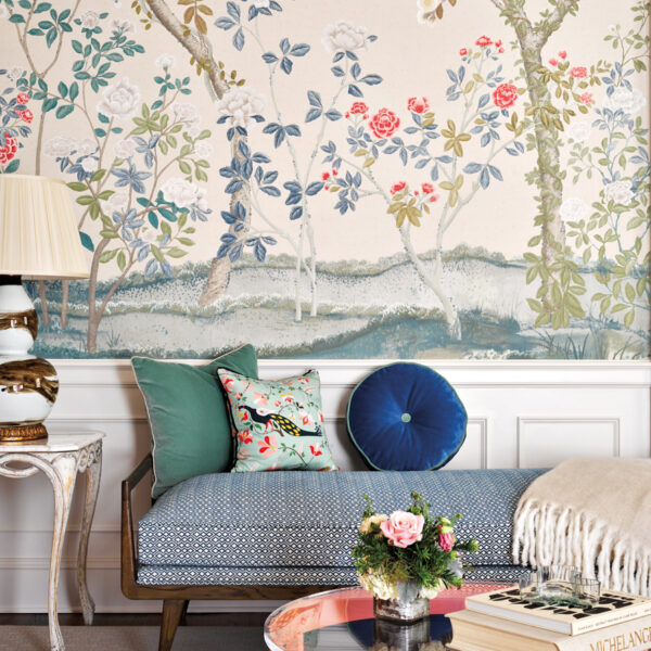 Nostalgia And Timeless Good Style Beckon In A 1939 N.C. Abode living room with flower and tree wallpaper, daybed with blue and green pillows and peach colored round table