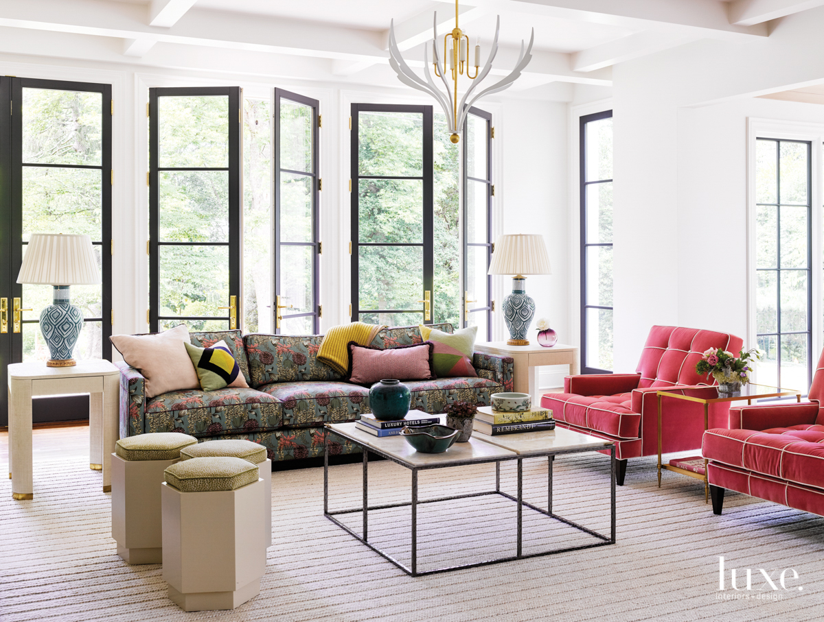living room with window doors, two red armchairs and a sectional