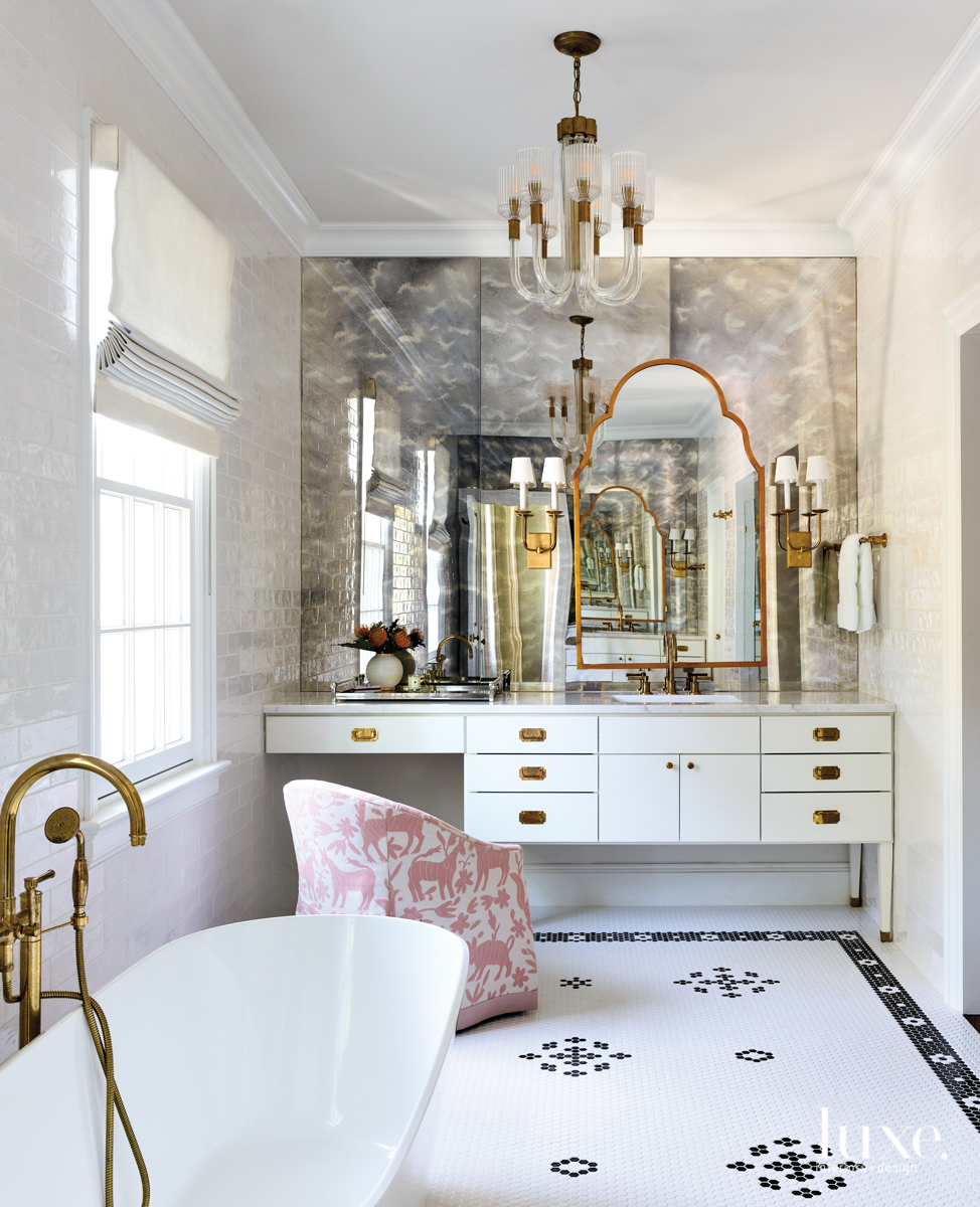 bathroom with stand alone tub, antiqued mirrors and lack and white hex tiles