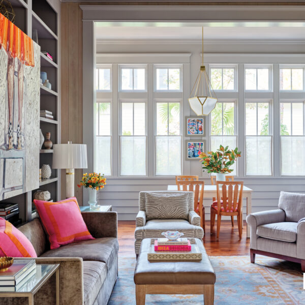 Consider This South Carolina Vacation Home An Ode To Summer And Sunrises gray media room with pops of pink and leather cocktail table