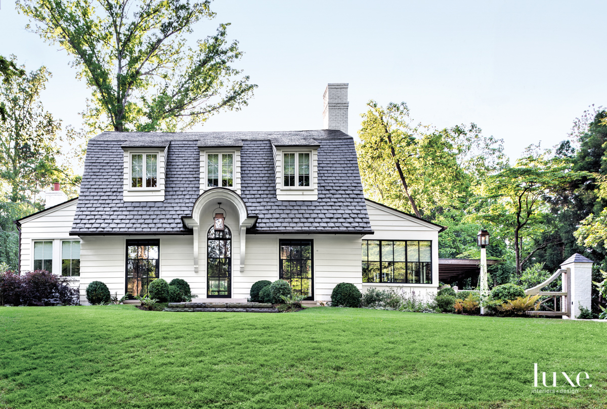 Dutch Colonial cottage with slate roof in front of green lawn