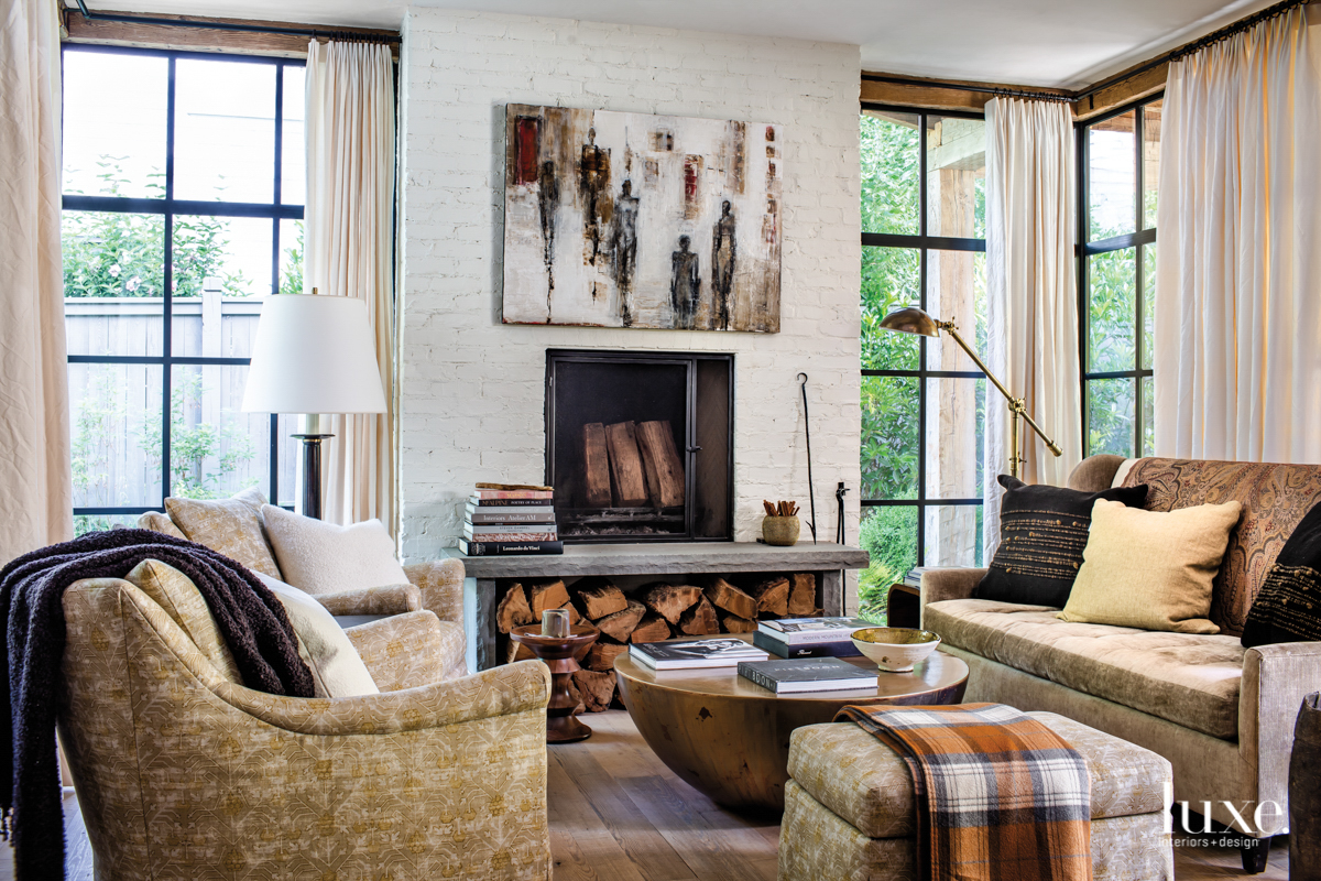 cozy furniture grouping next to white brick fireplace with plaid blanket