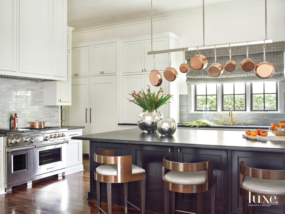 kitchen with a custom pot rack, island and barstools
