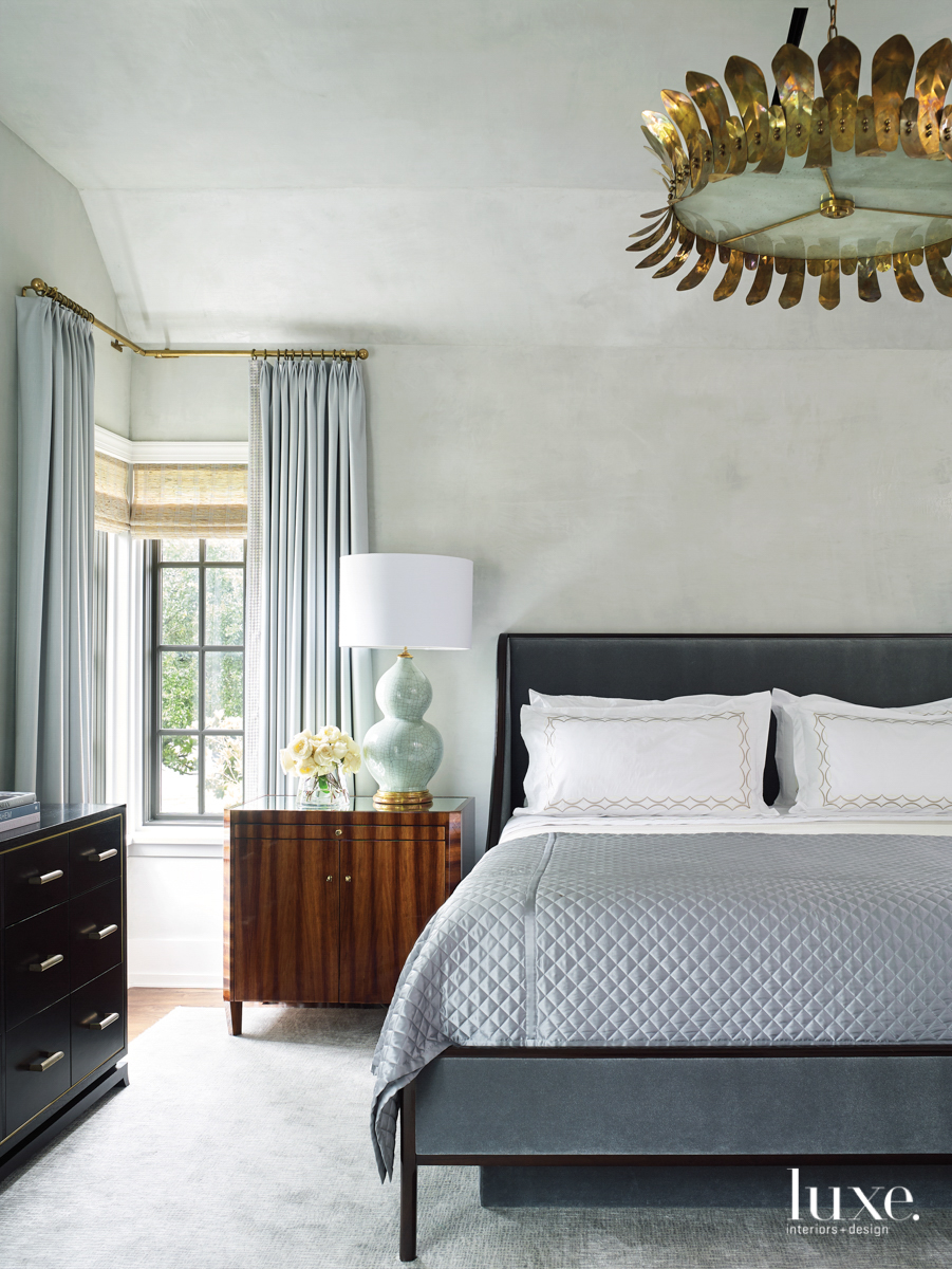 msater suite featuring an italian brass-and-glass chandelier, silk coverlet for the bed and a chest