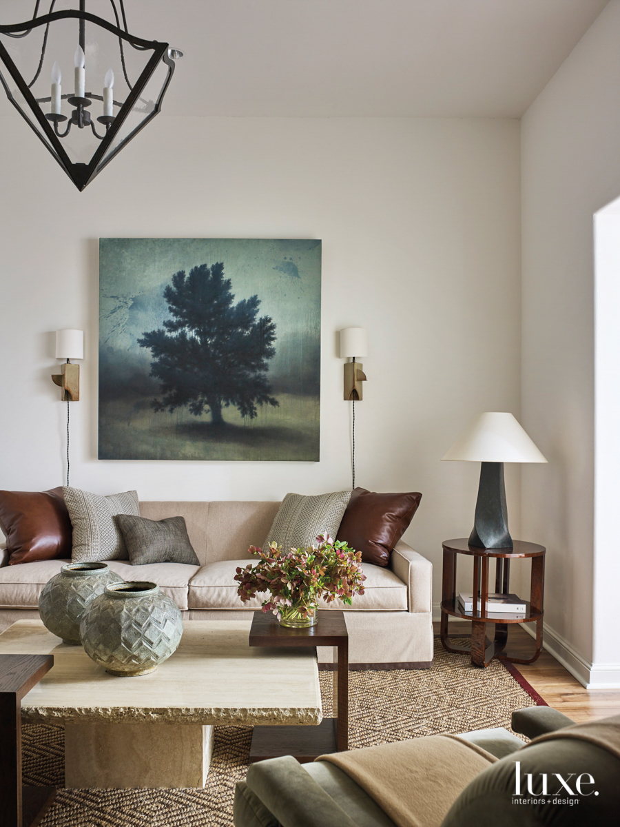living room featuring art, a sectional, armchair and brown, red and tan tones