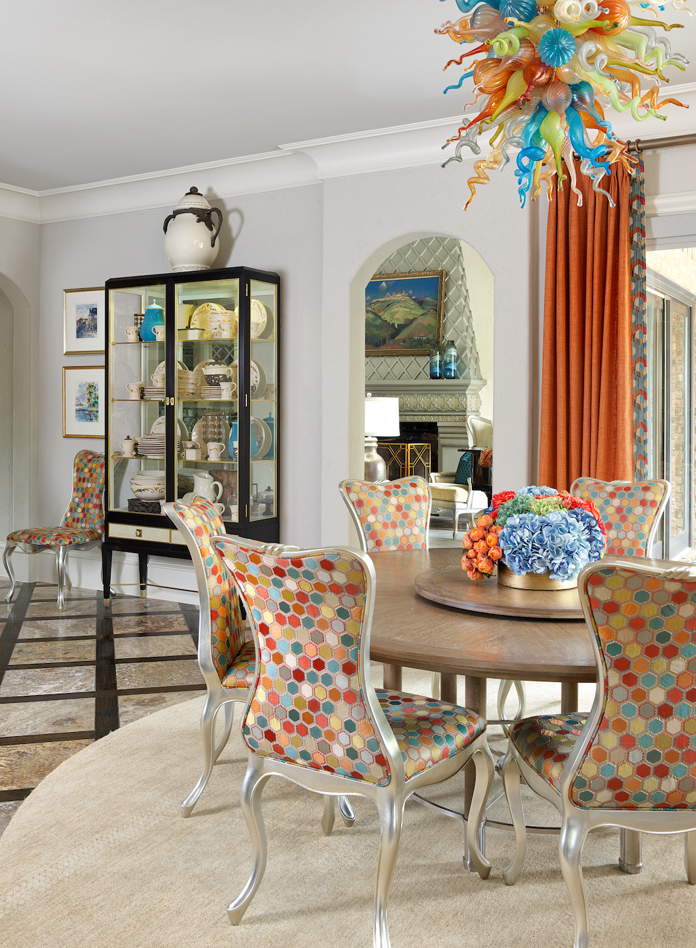Orange fabric window curtains and multi fabric dining chairs