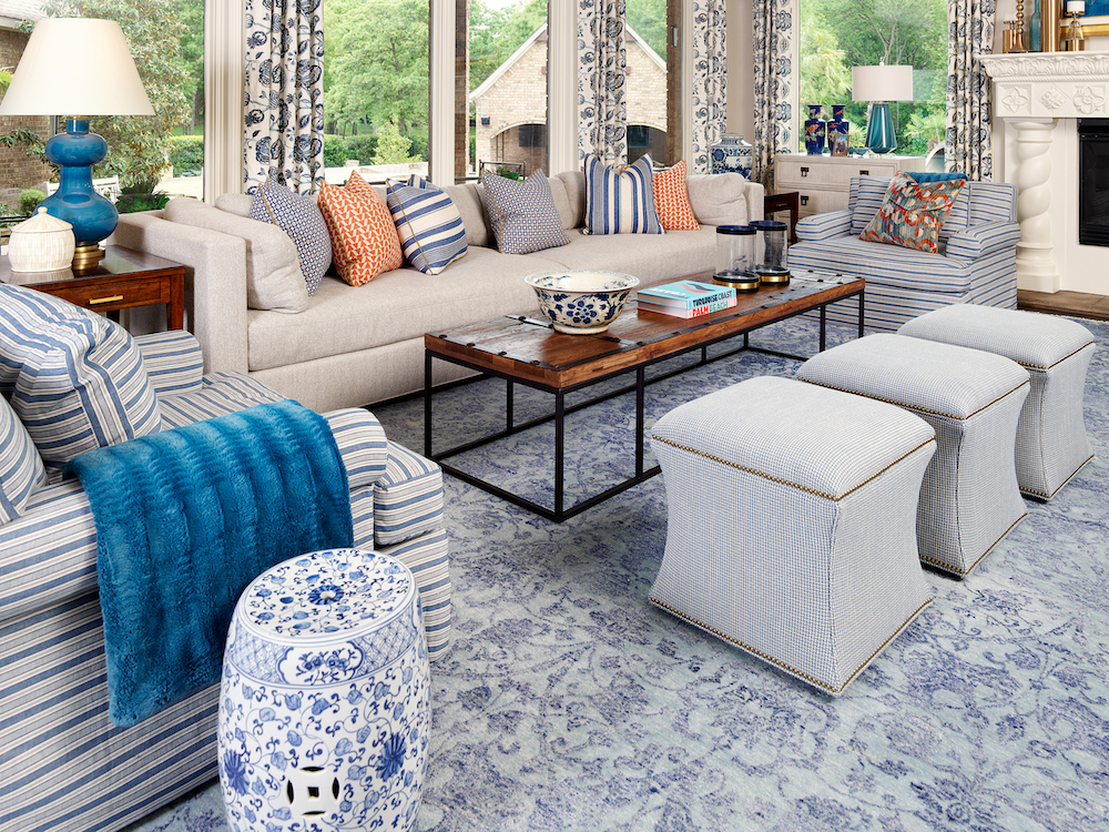 Blue patterned rug with cream couch and wood coffee table living room