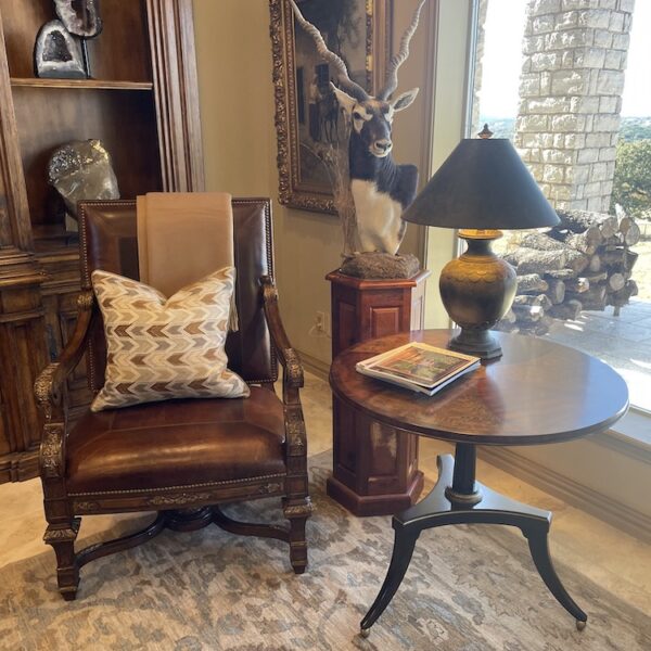 Brown leather chair with cream patterned pillow