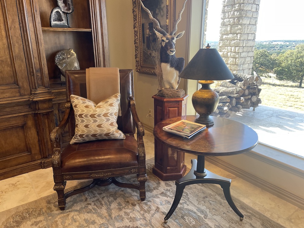 Brown leather chair with cream patterned pillow