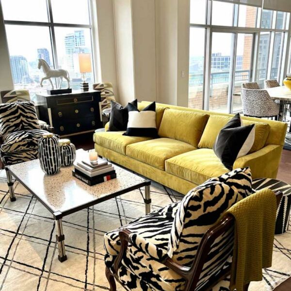 Lots of light in this living room with a yellow sofa and animal print fabric chair