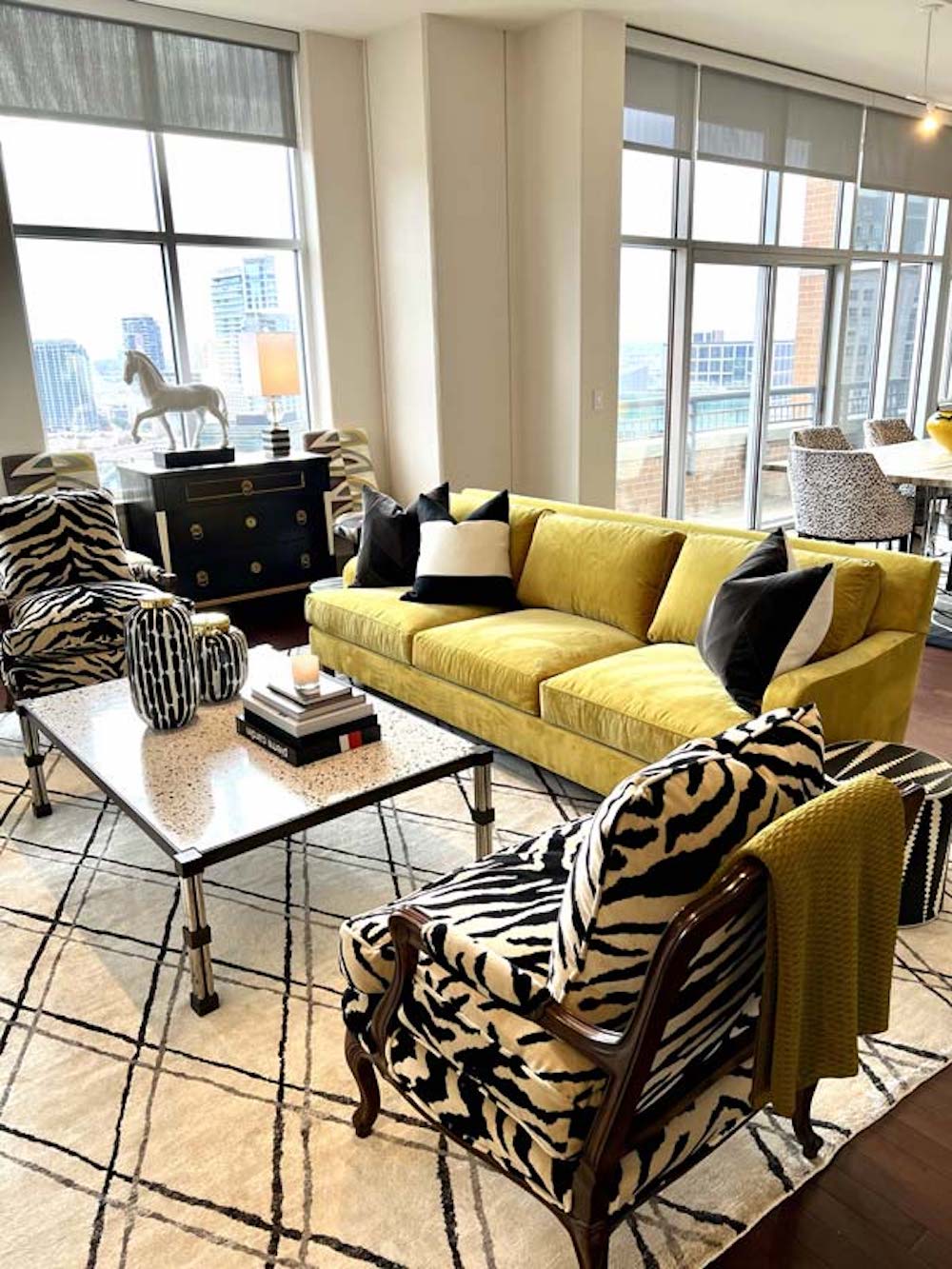 Lots of light in this living room with a yellow sofa and animal print fabric chair