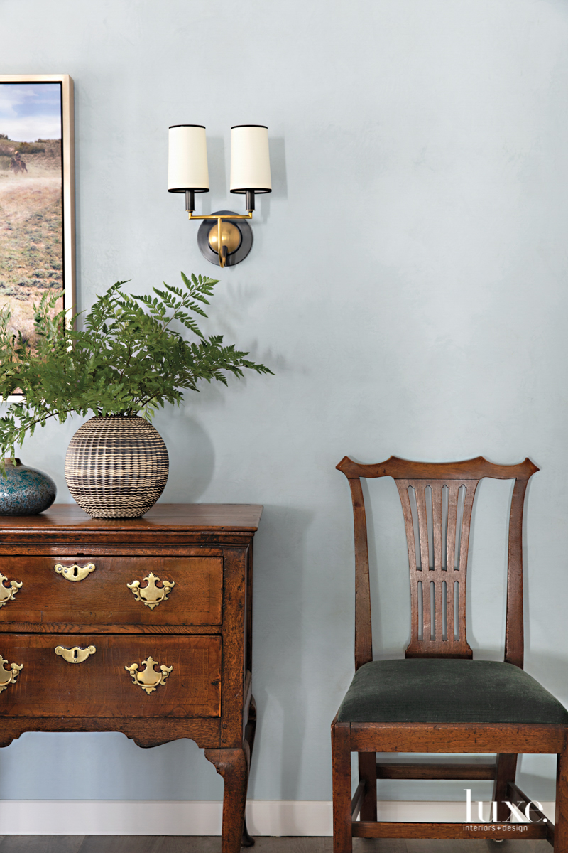 wooden sideboard and chair and sconces