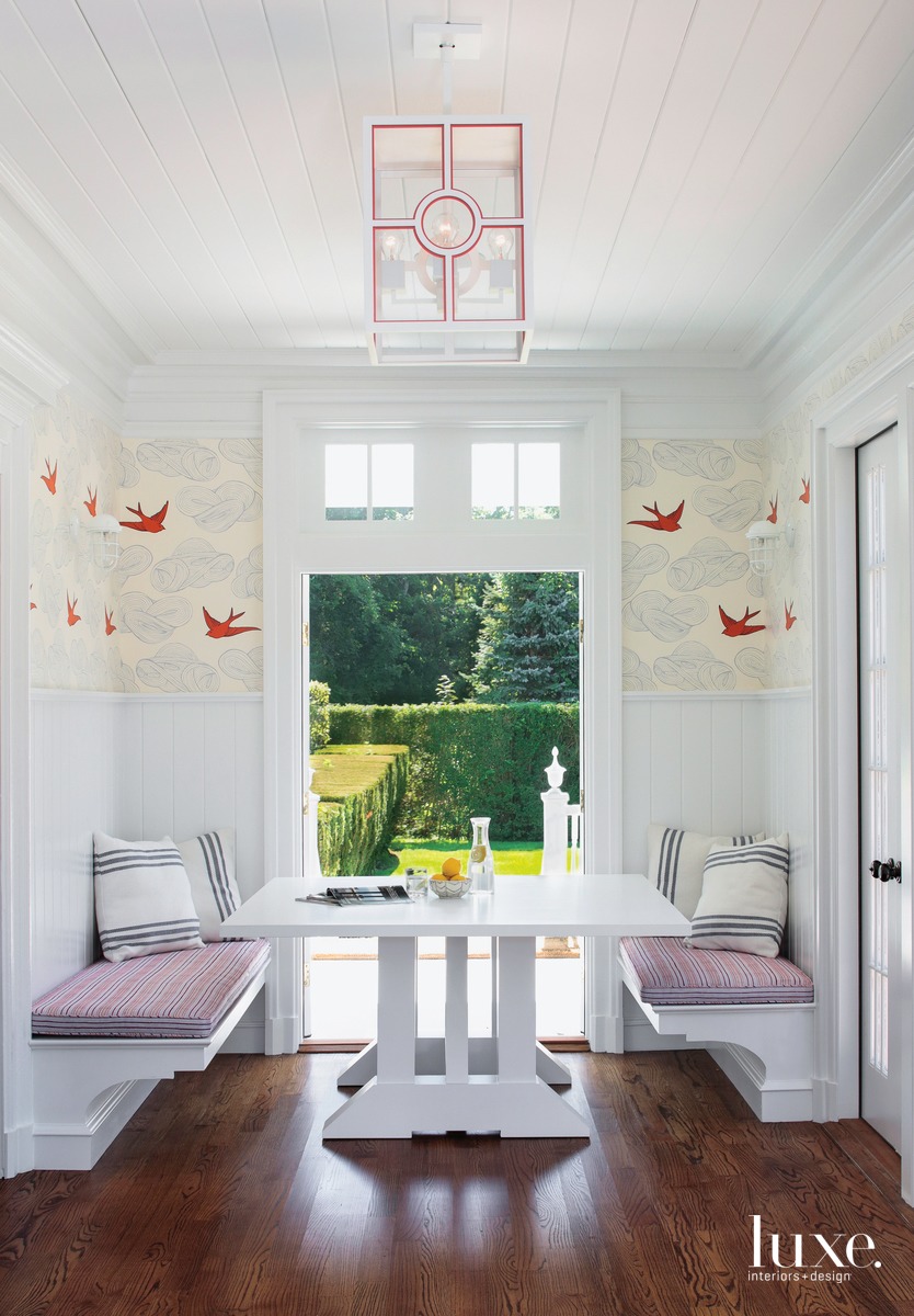 white breakfast nook with delicate origami wallcovering and a pink-and-white lantern chandelier