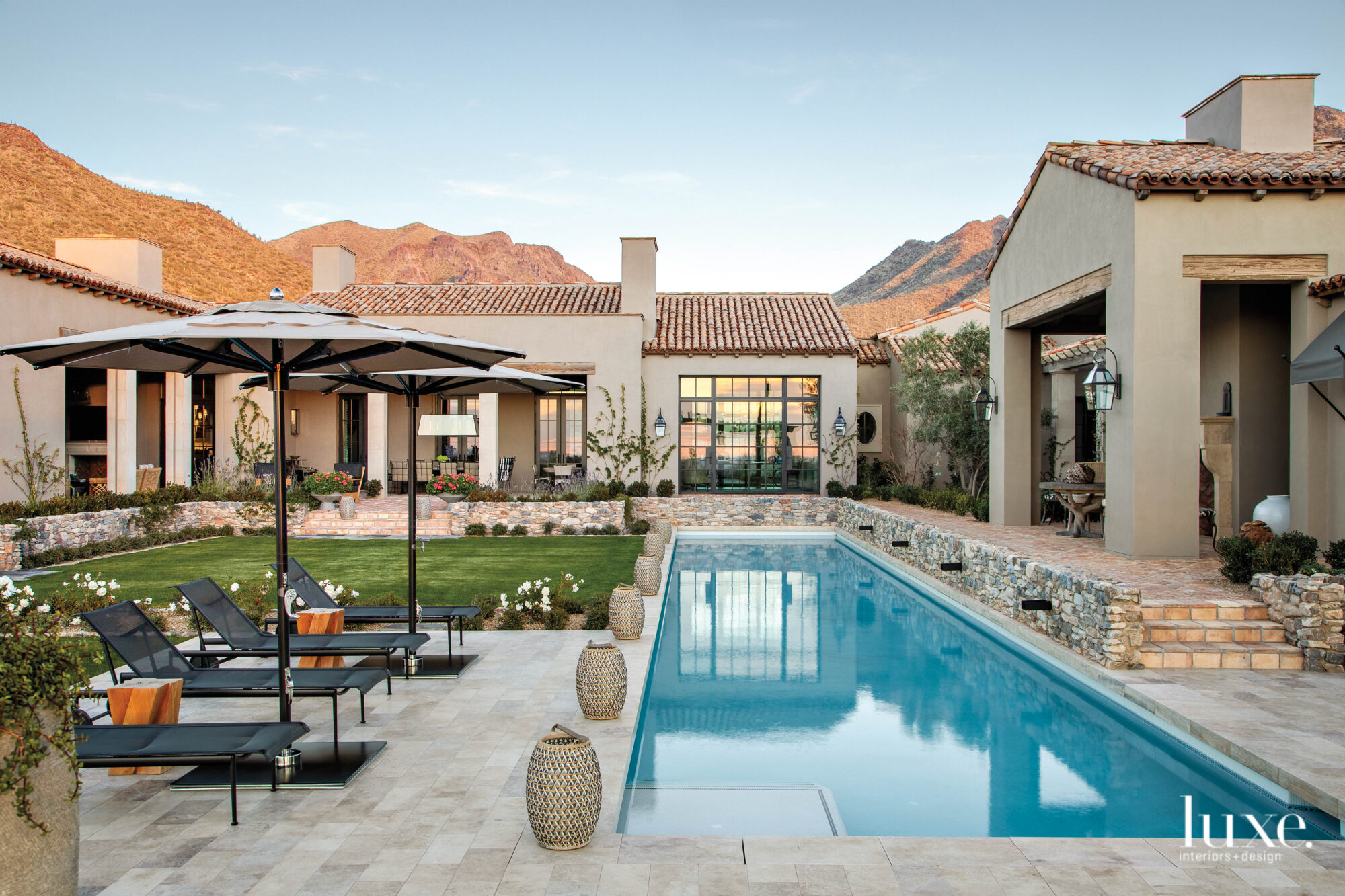 Mountains and the Mediterranean architecture serve as the poolside view
