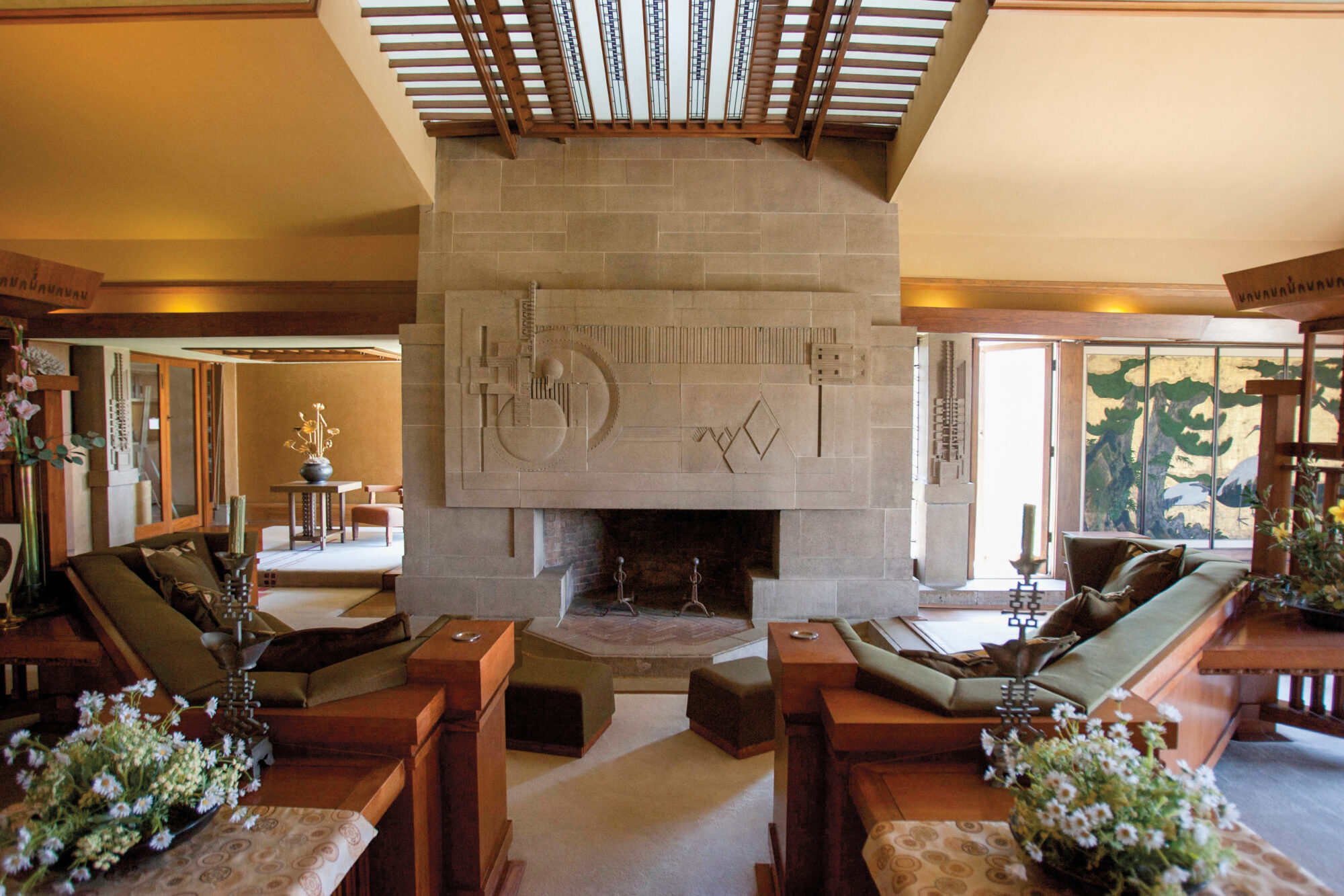 Frank Lloyd Wright's Hollyhock House's living room with seating and fireplace