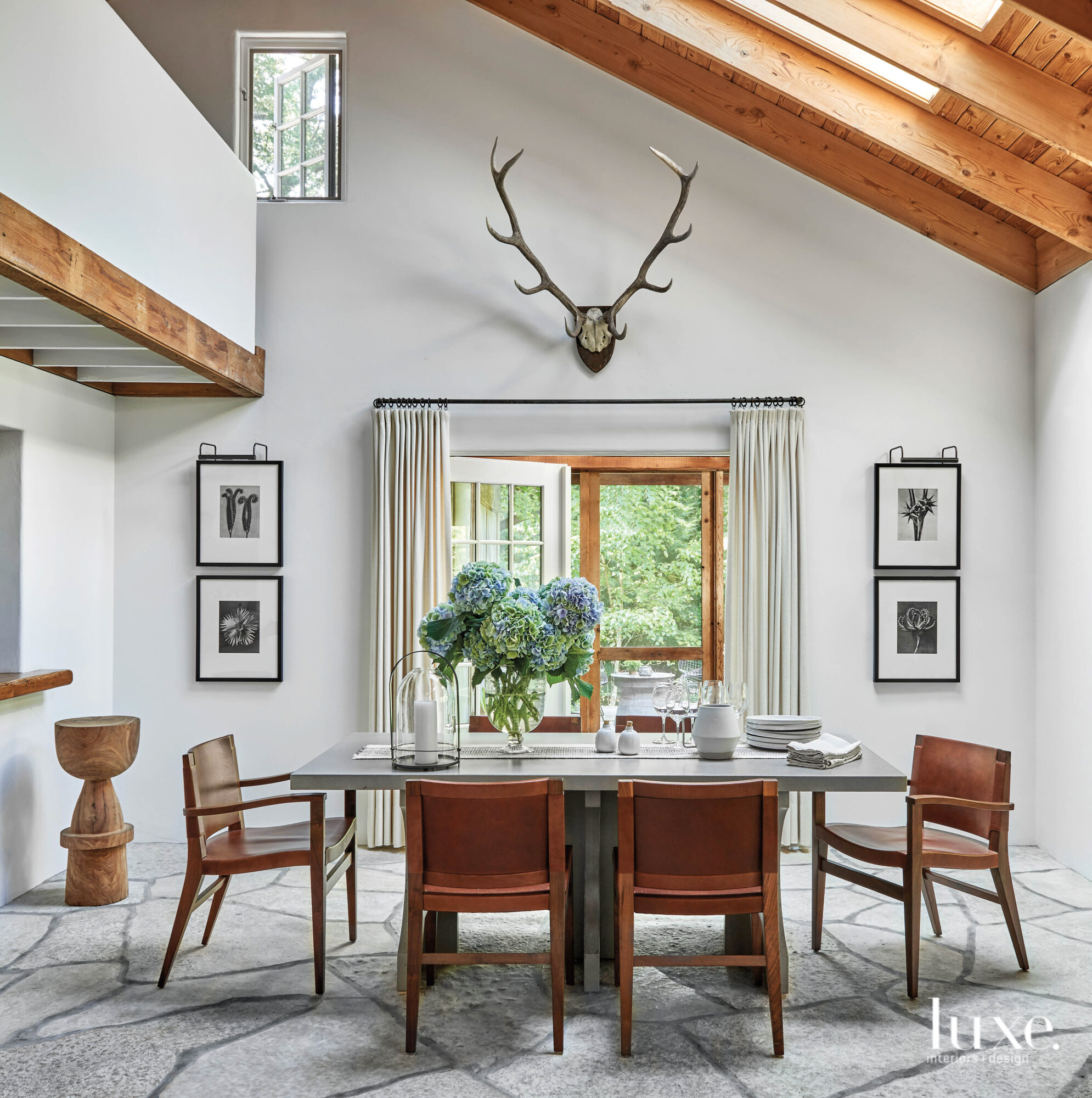 A simplistic, symmetrical dining room is decorated with wooden finishes.