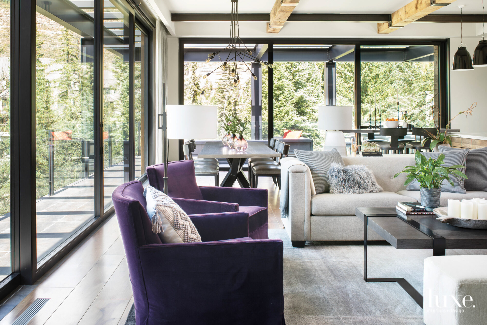 A living room features a pair of purple chairs and a neutral sofa.