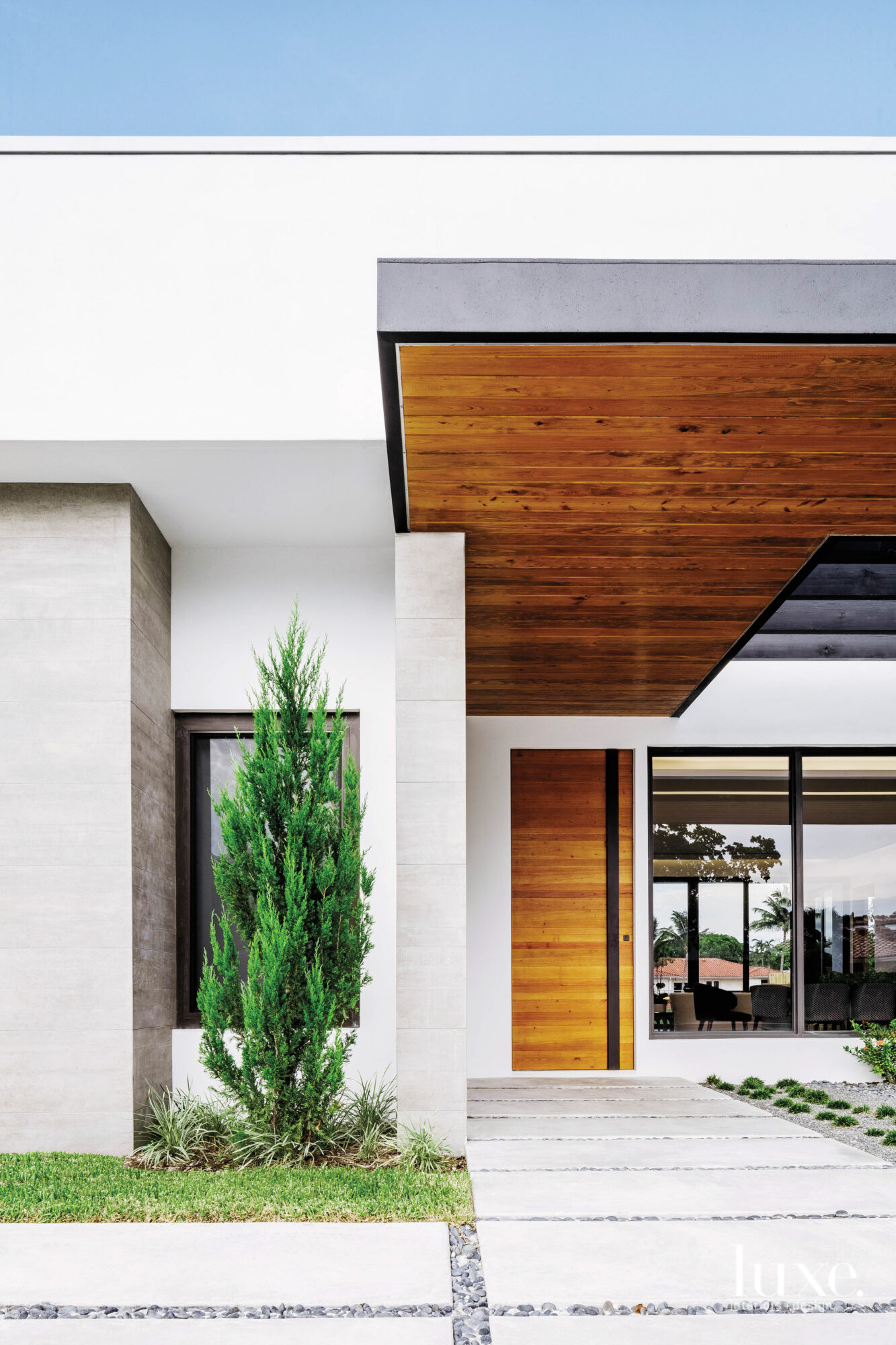 The exterior of the house features a concrete tile walkway leading to a walnut door