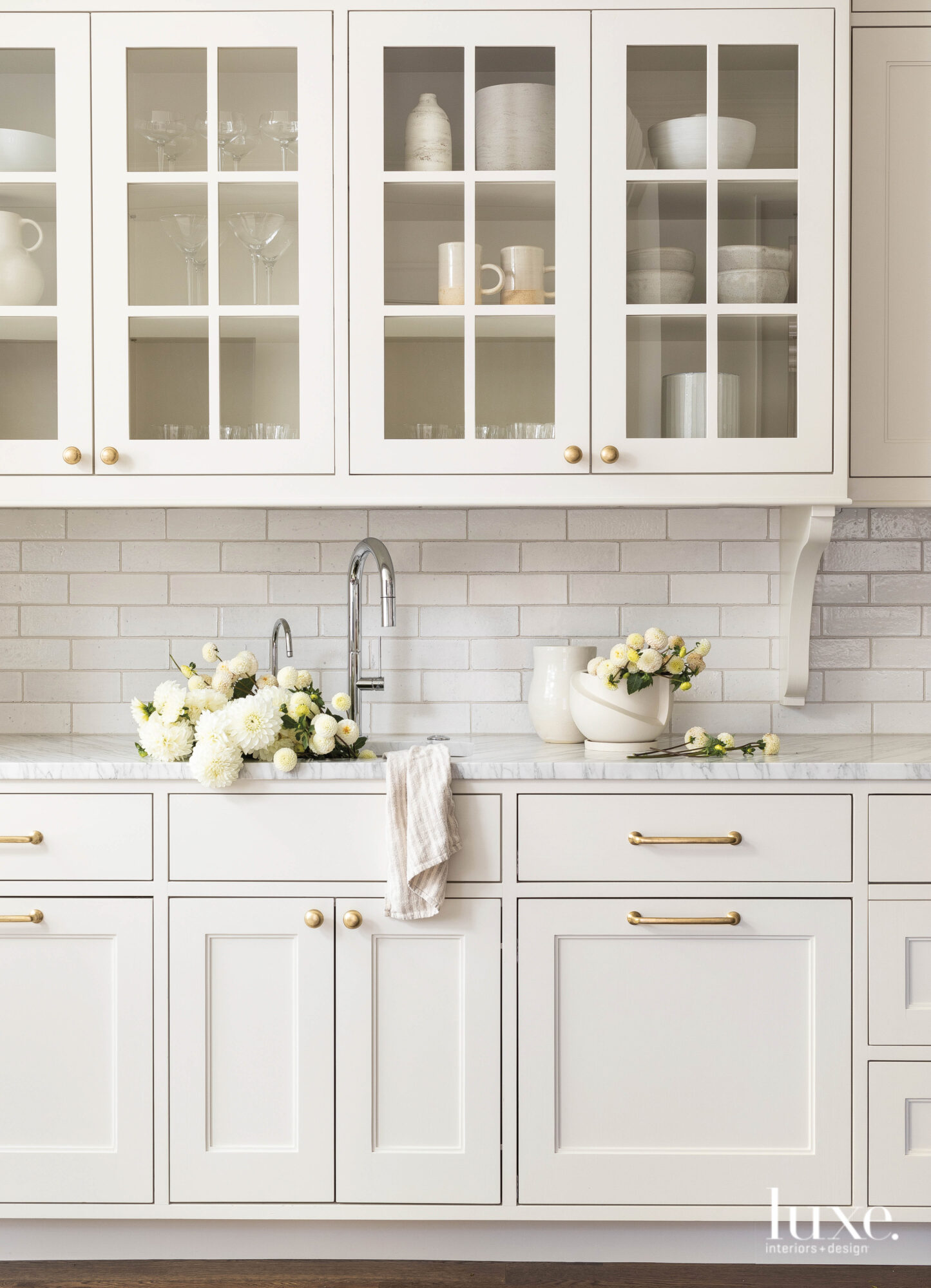 Kitchen space with white cabinetry and white tile.