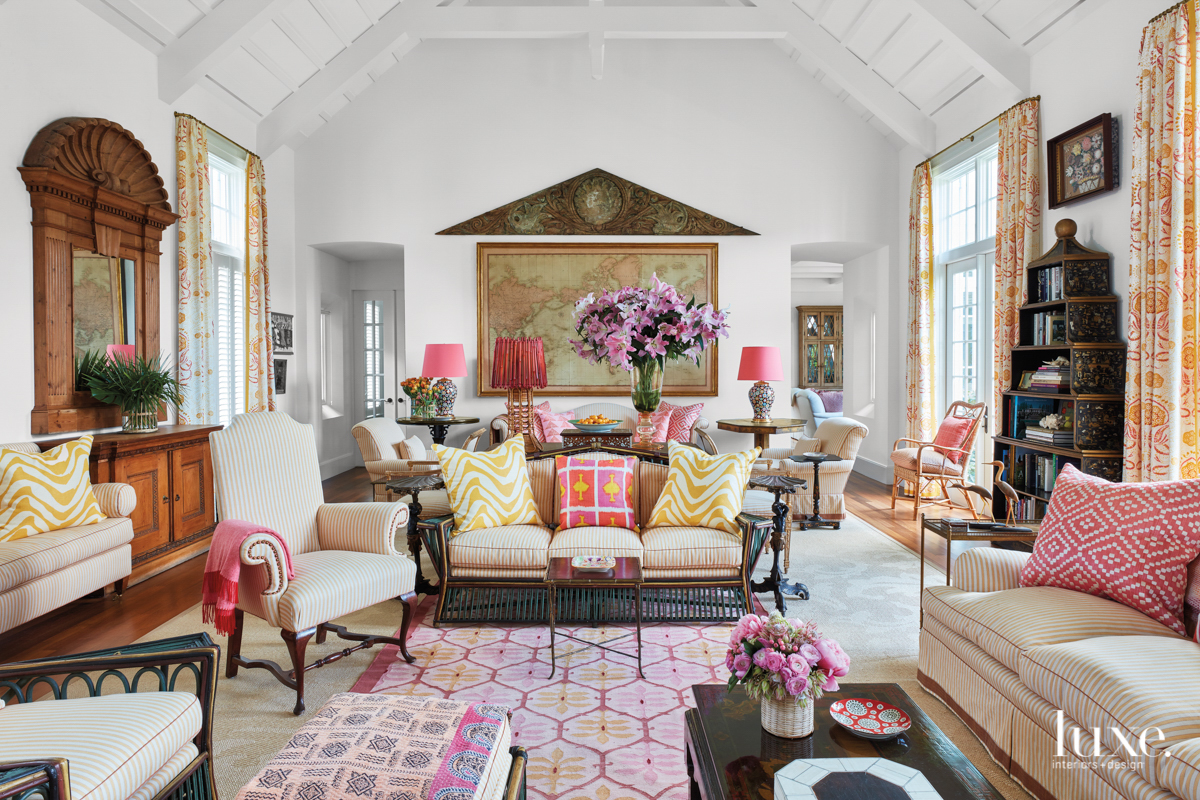 white vero beach living room with pops of coral and orange and antiques