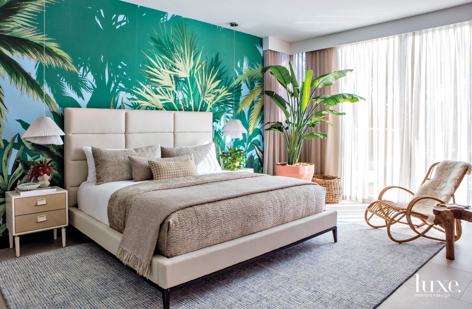 Guest bedroom with a bright green wallcovering with palm tree pattern.