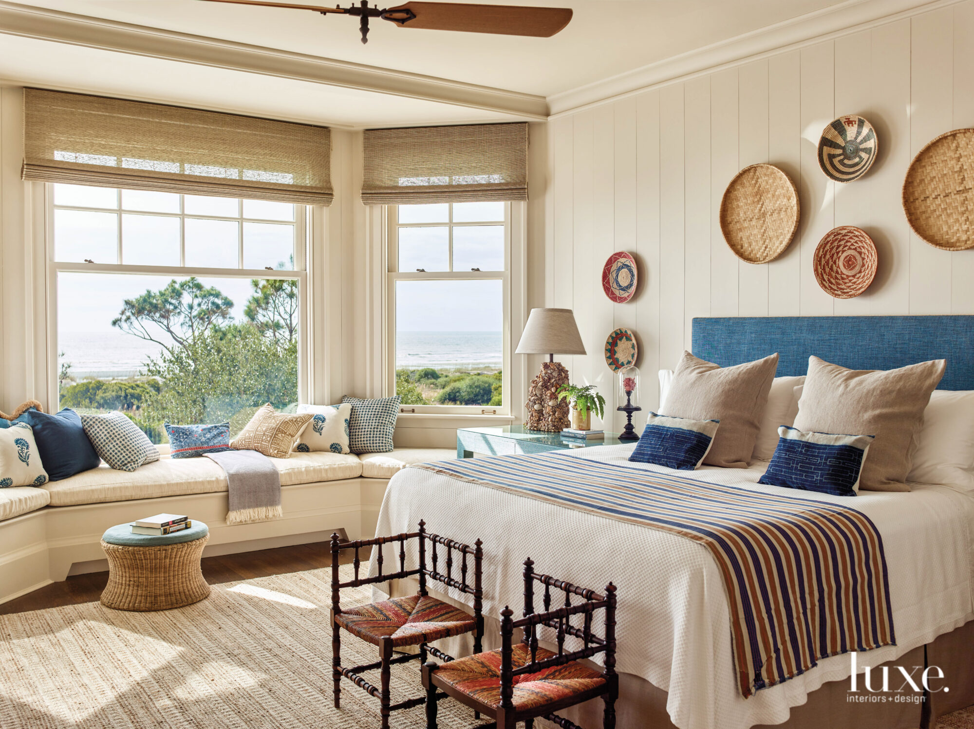 Ivory bedroom with vertical paneling, bay window seat and view of the ocean