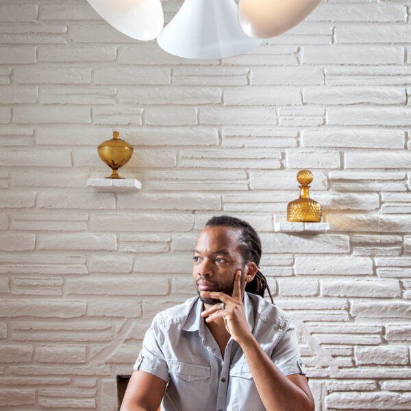 Lighting designer Raymond Barberousse sits among some of his creations.