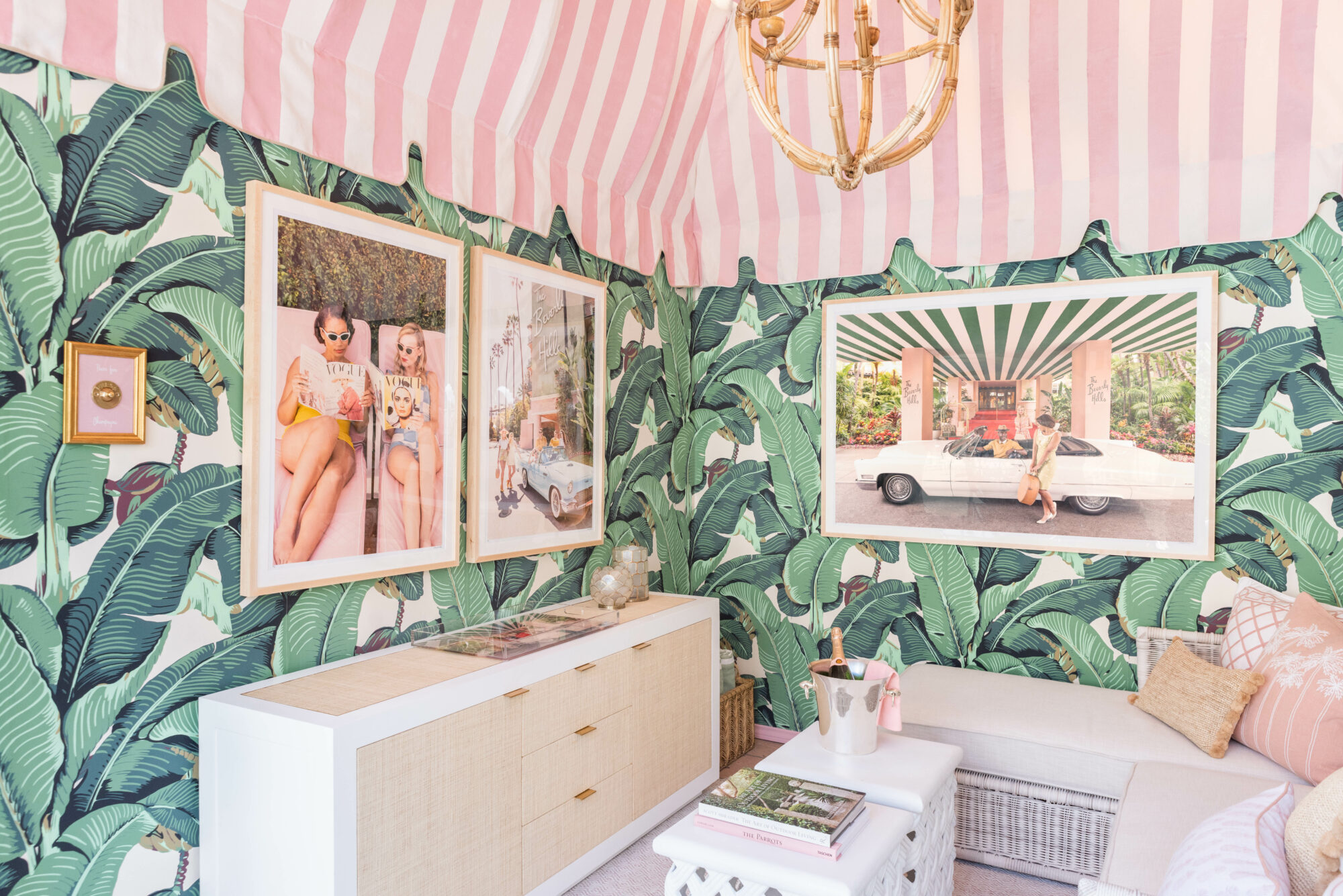 The pink-striped canopy and Gray Malin's artwork are visible from this angle of the cabana