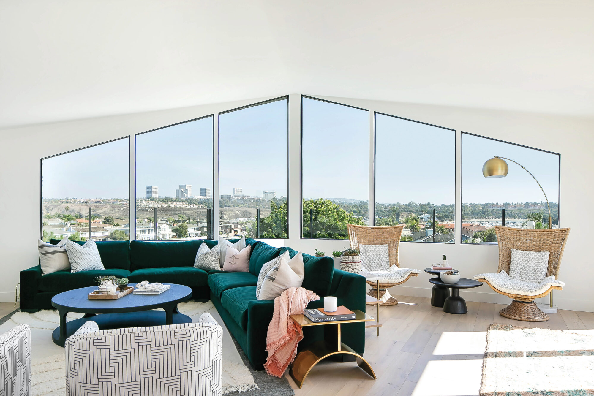 Living room with view facing city and large green couch prominently shown.