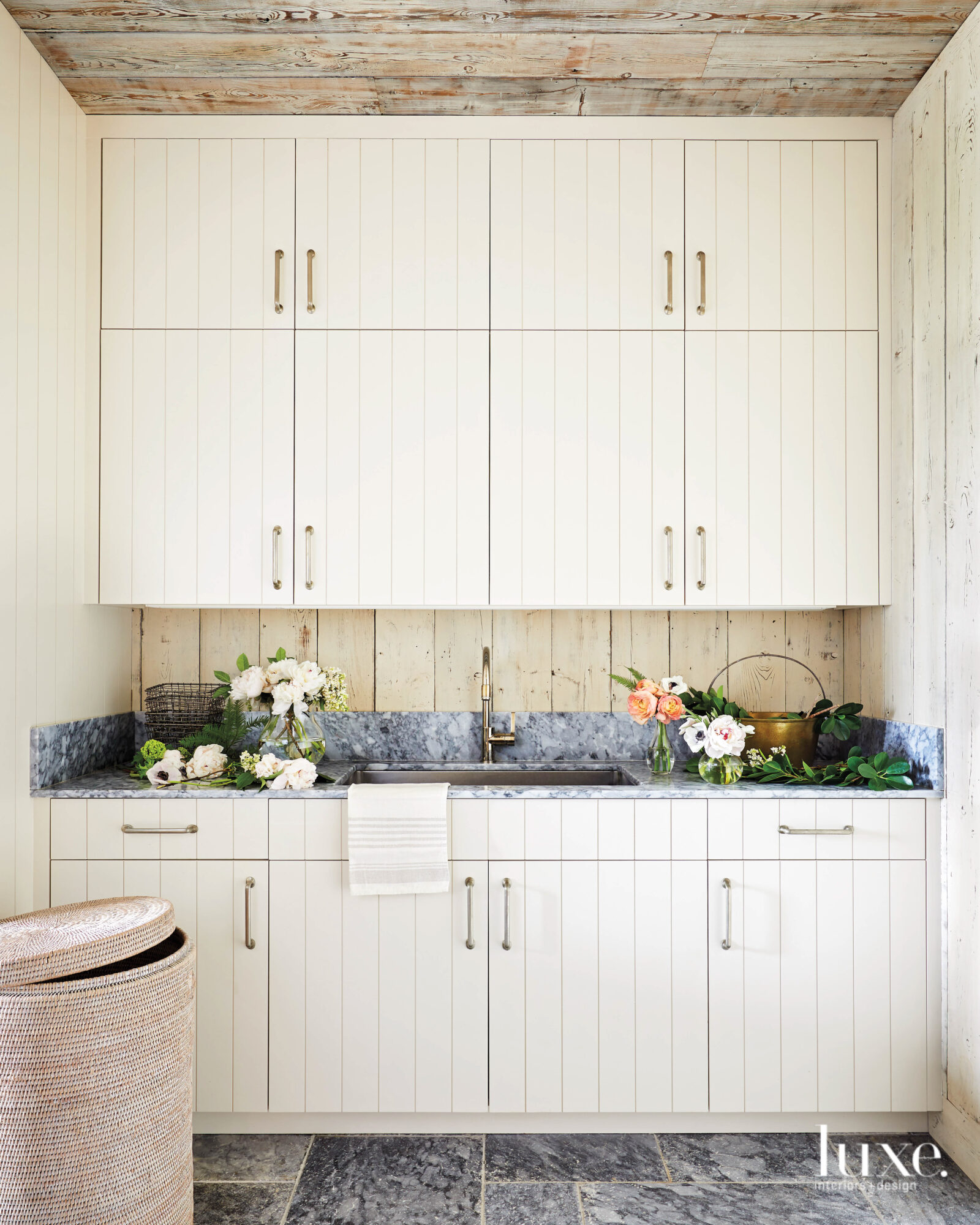 White cabinetry and a unique backsplash behind the kitchen sink