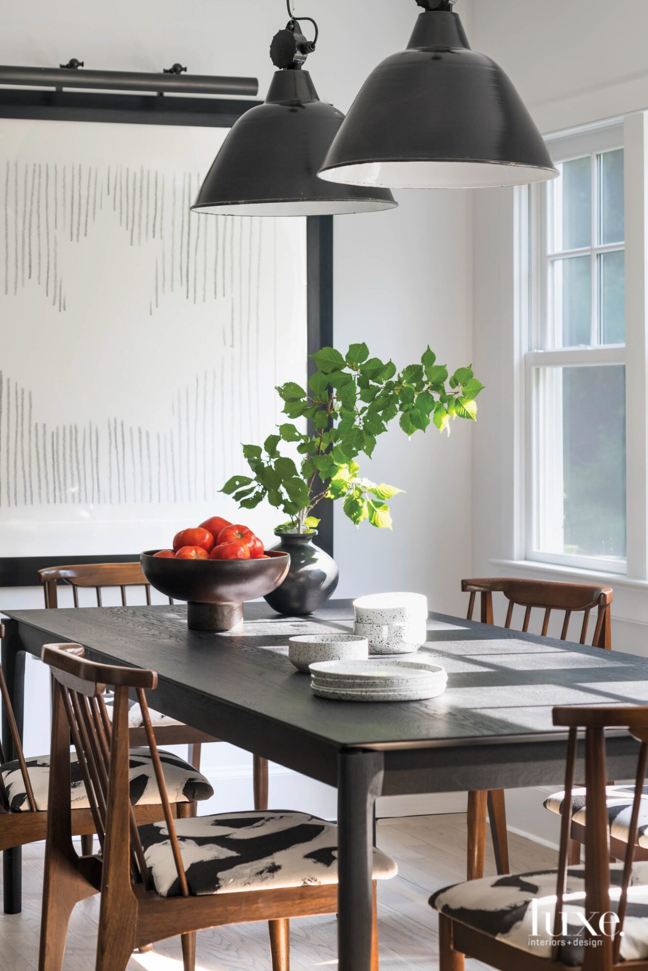 Dark wood define a dining table that sits in a room full of bright light