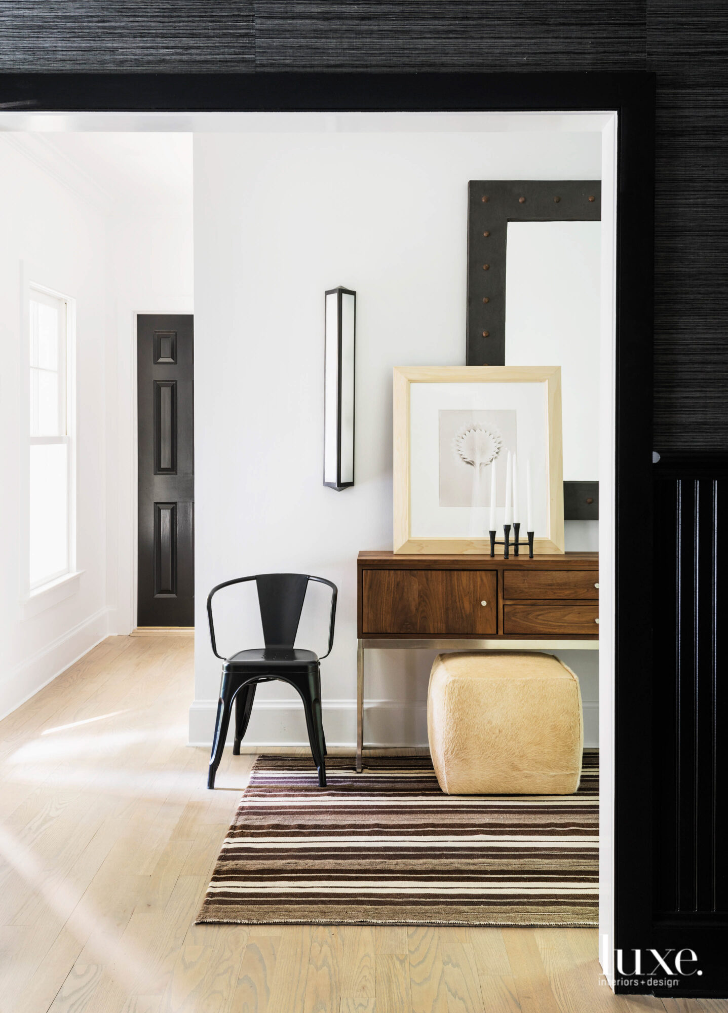Black chair sits next to wooden table in the entryway