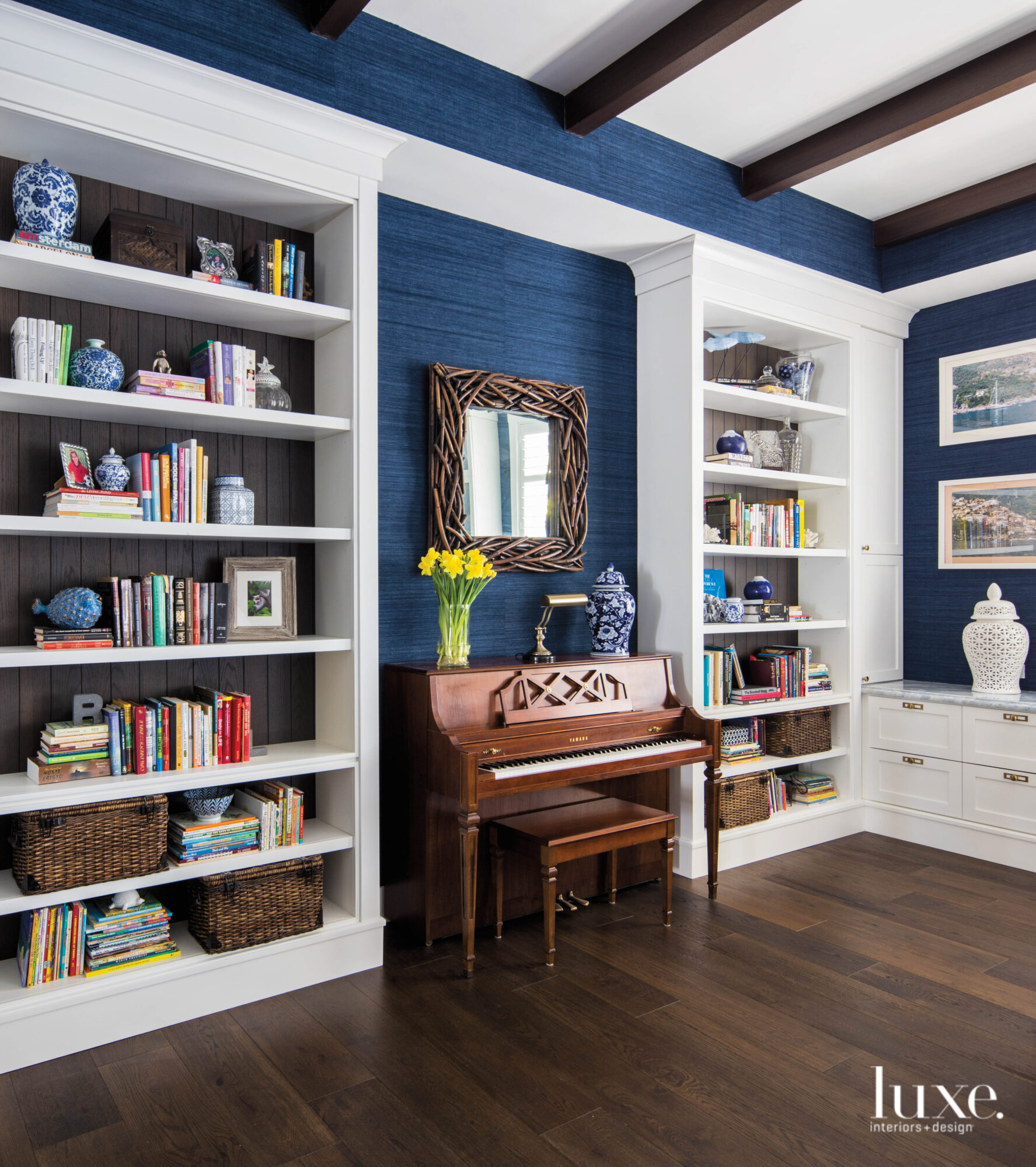 Bar and lounge area with navy walls, piano and white bookshelves