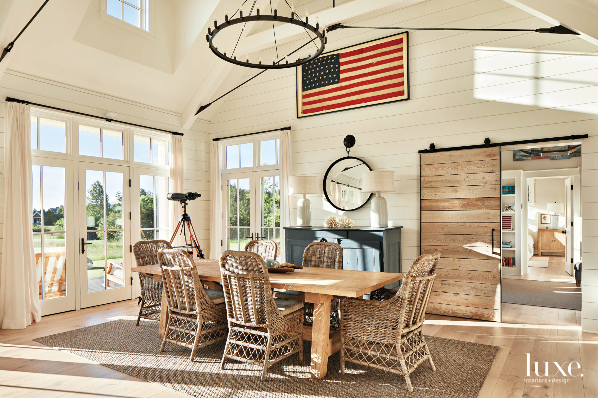 Dining room with rattan chairs and farmhouse table and American flag