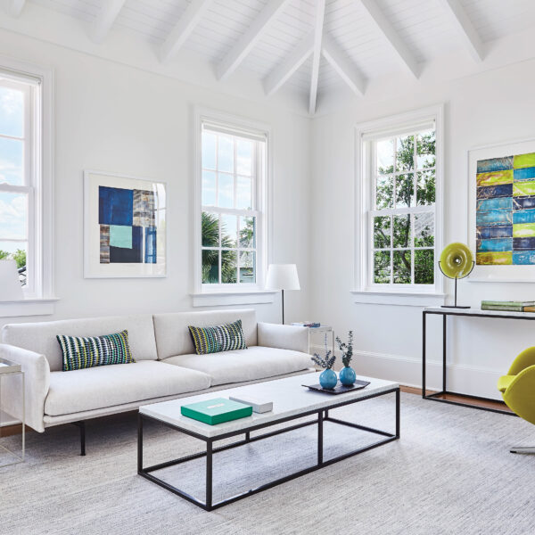 Take Two: A Florida Home’s Original Architect Returns To Brighten Up A Vacation Retreat’s Historical Design Media room with chartreuse Egg chair and marble coffee and console tables.