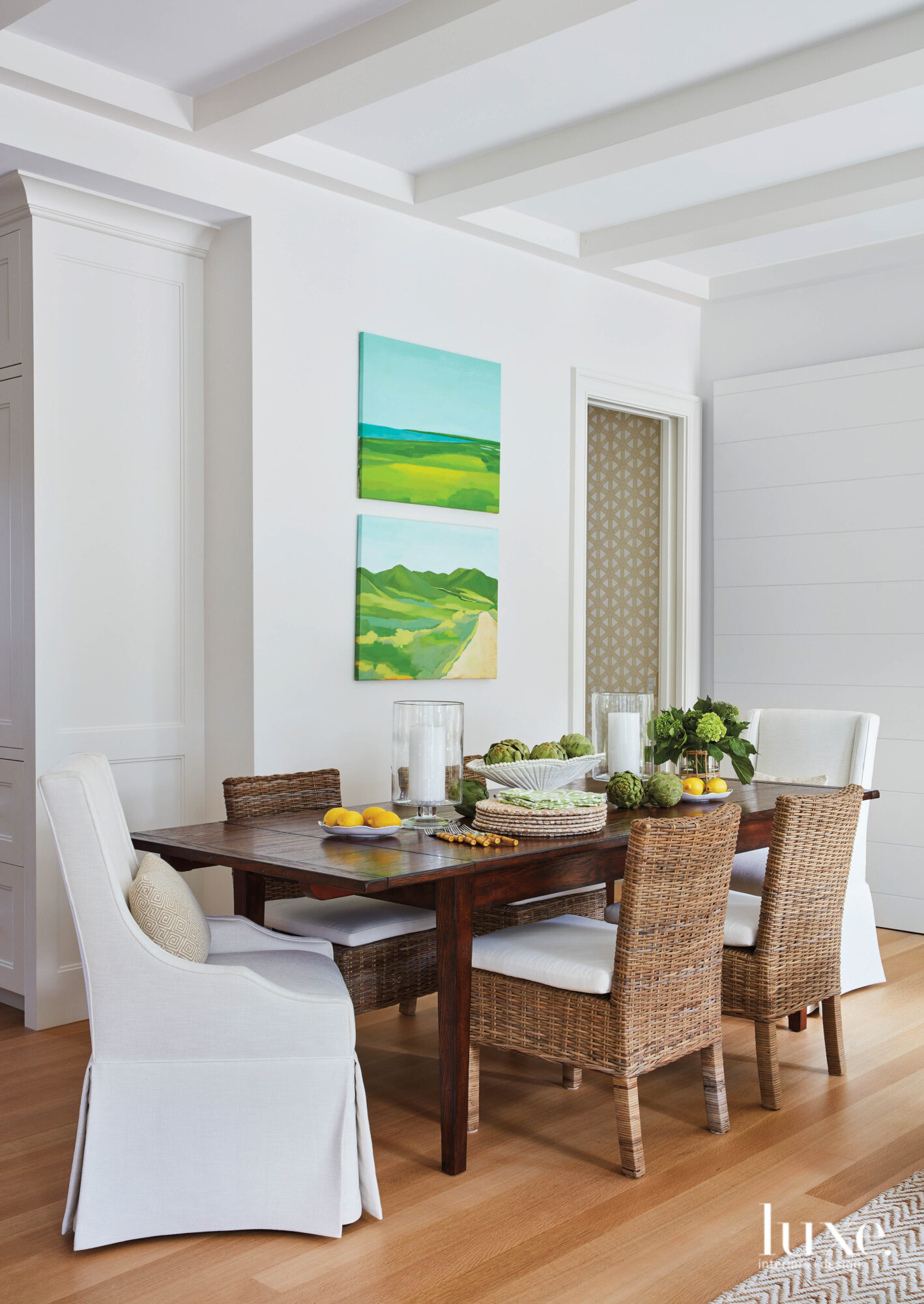 Dining room with wood table, wicker side chairs and skirted head chairs.