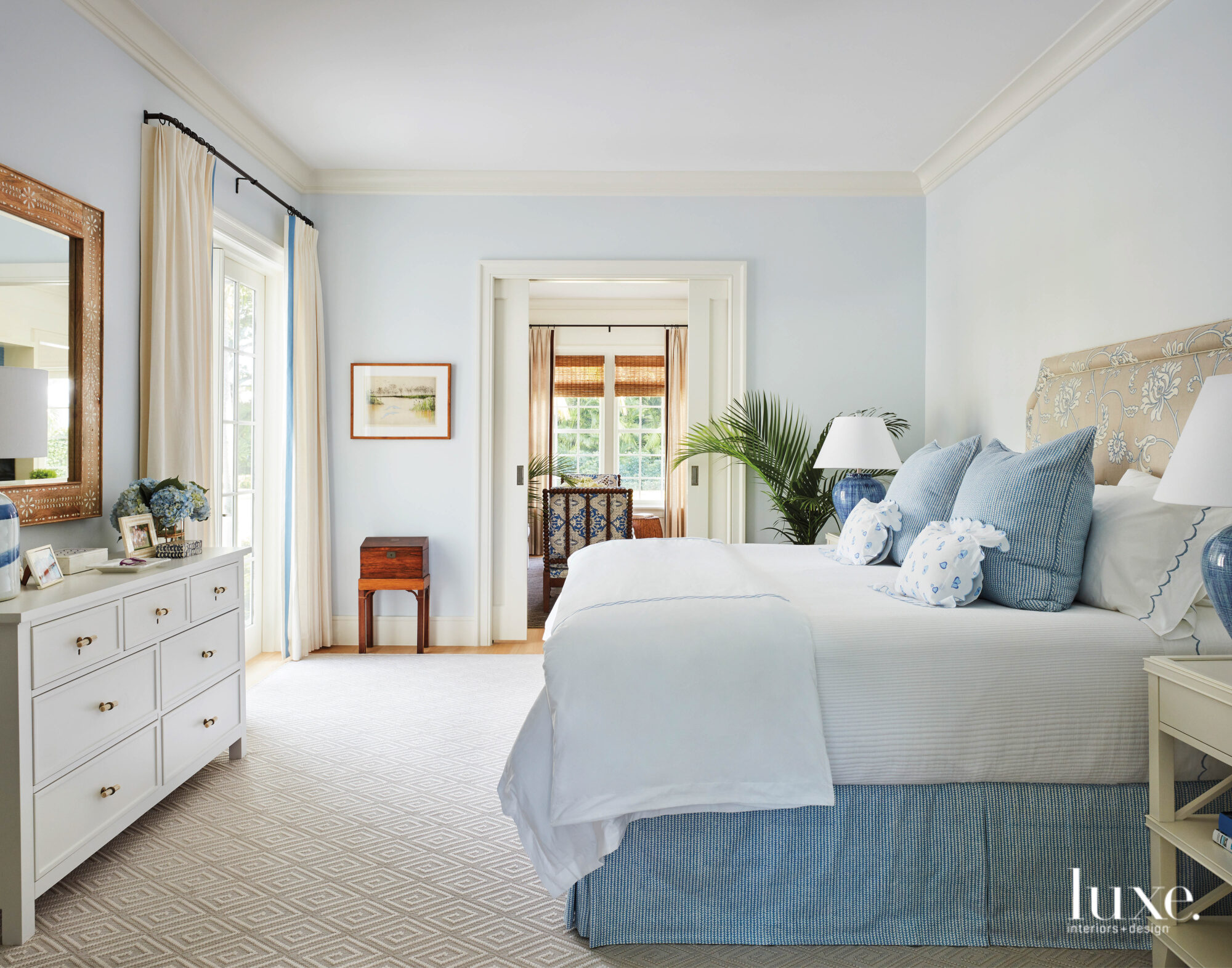 Main bedroom with blue and white bedding on top of a sisal rug.