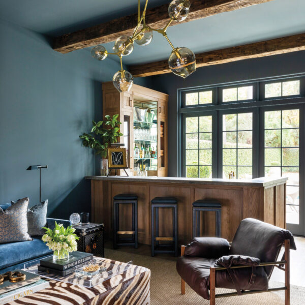 Renovating Their House Helps A Houston Family Feel Right At Home Dramatic seating area with dark blue walls and a bar.