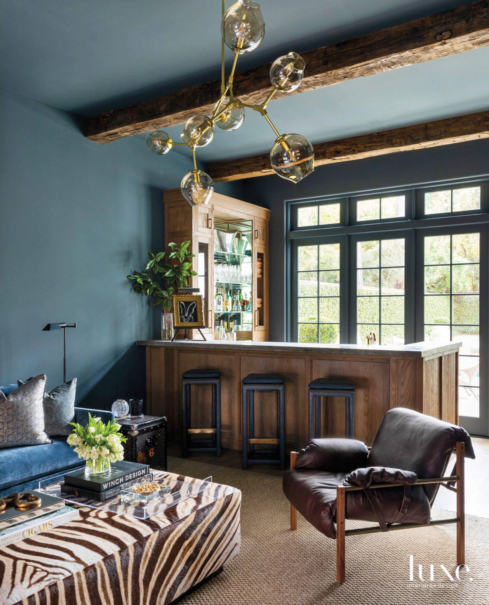 Dramatic seating area with dark blue walls and a bar.