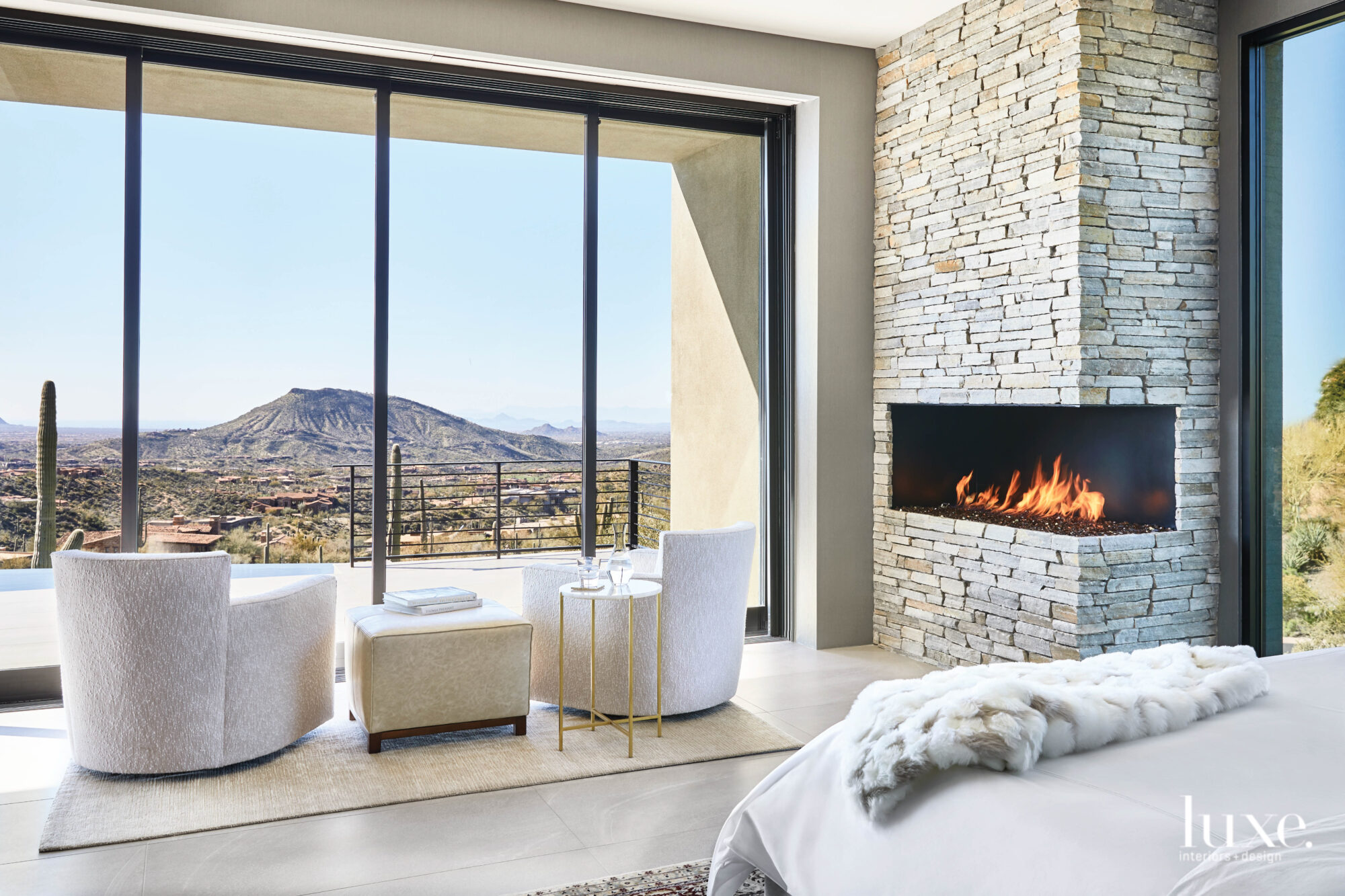 The master bedroom has a corner fireplace and a seating area overlooking the mountains.