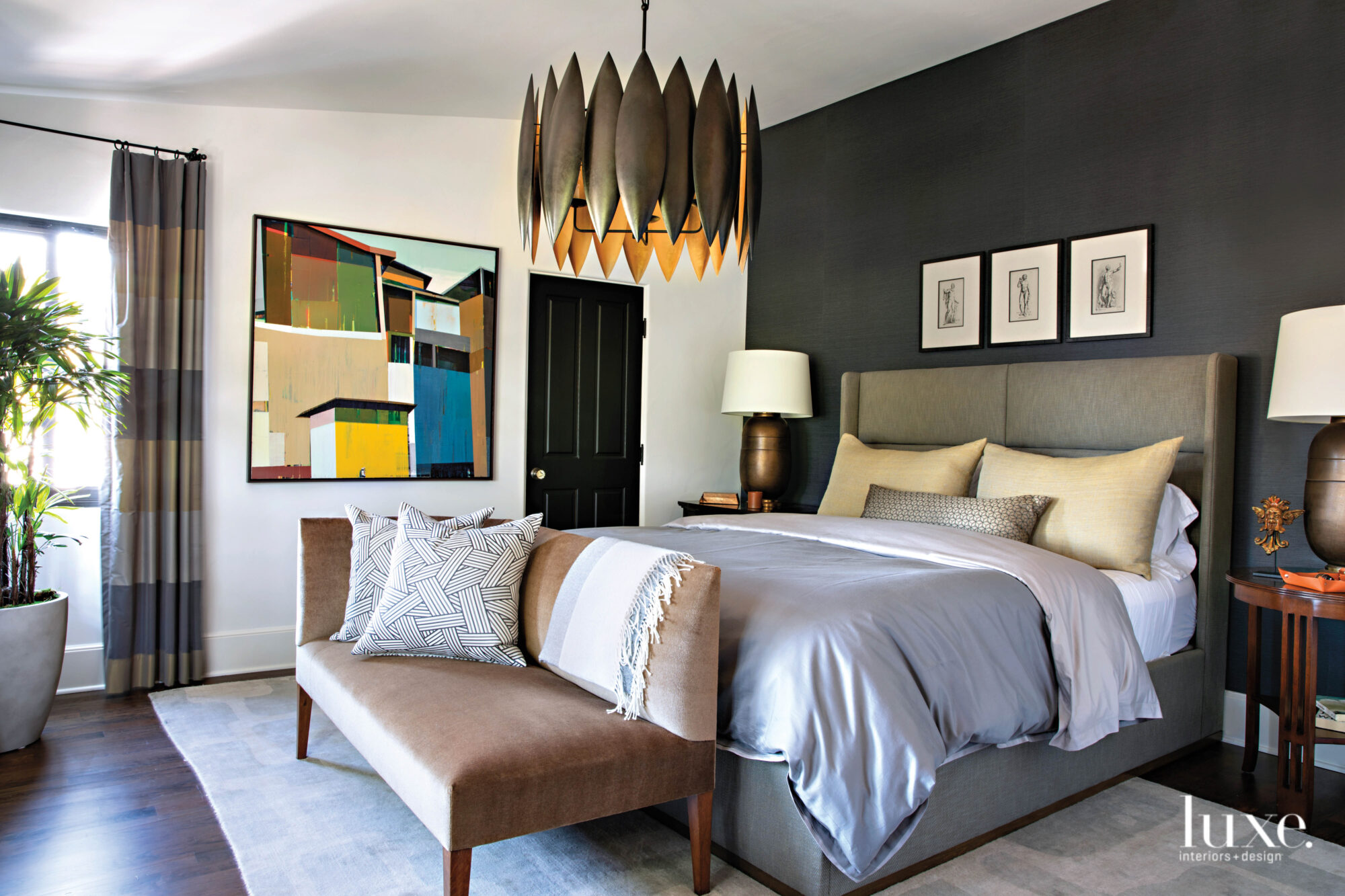 BEdroom with dark accent wall behind bed frame and contemporary light fixture above