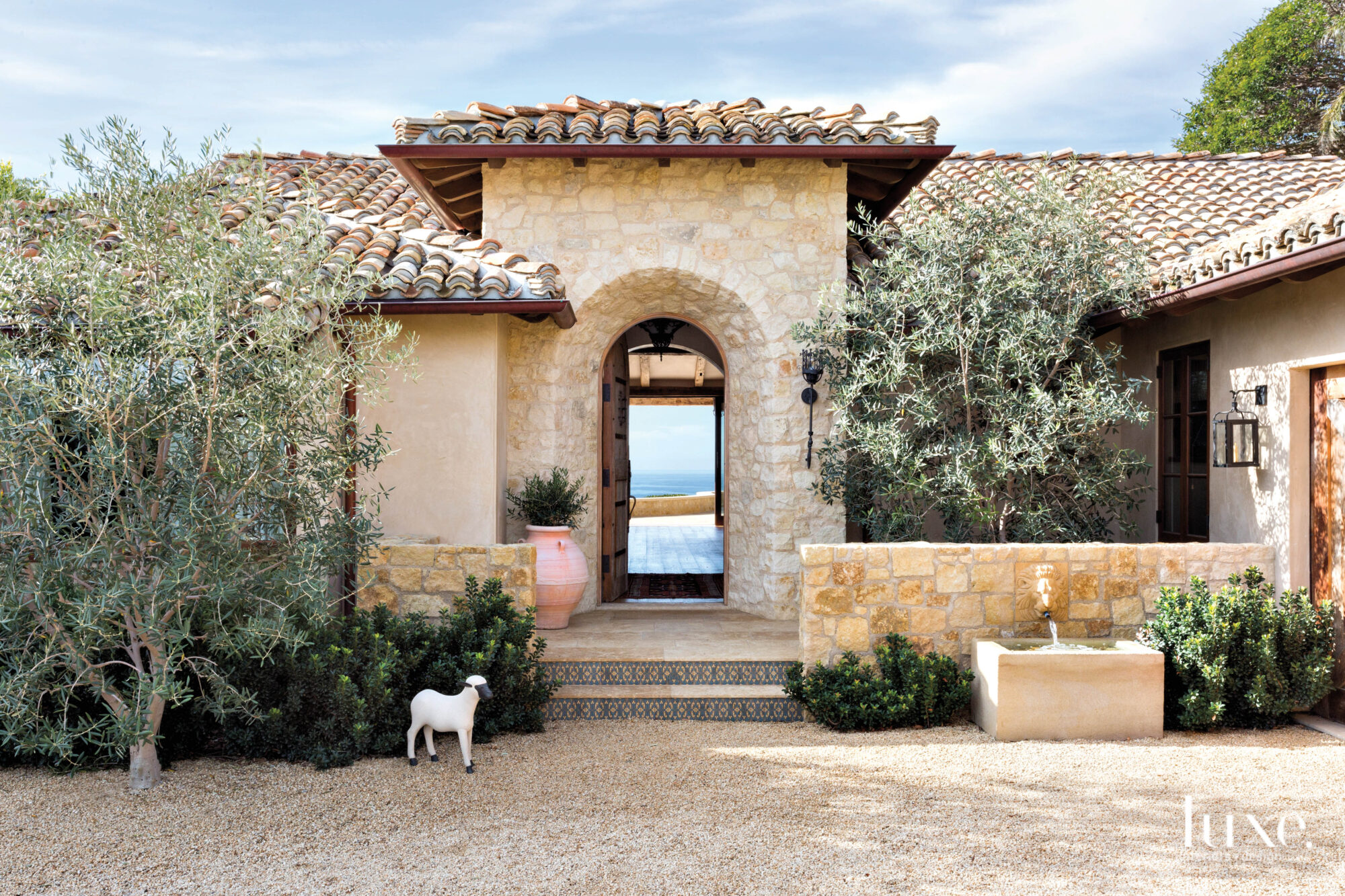Entry to Mediterranean-style Malibu home with sheep at entrance.