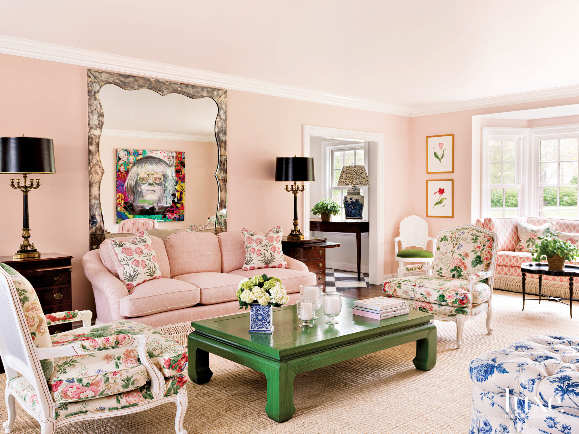 Pink living room with floral armchairs, a green coffee table and a pink couch