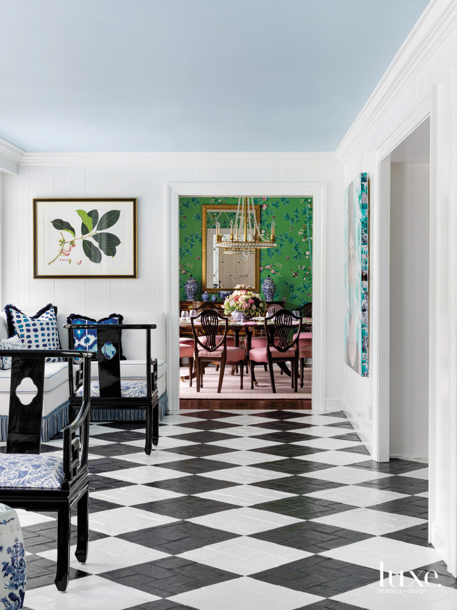 The sunporch has black-and-white floors and looks into the dining room.