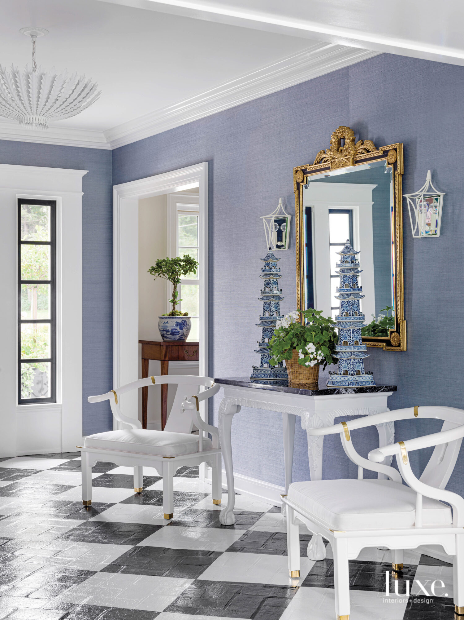 The foyer has blue walls, black-and-white checkered floors and vintage furniture.