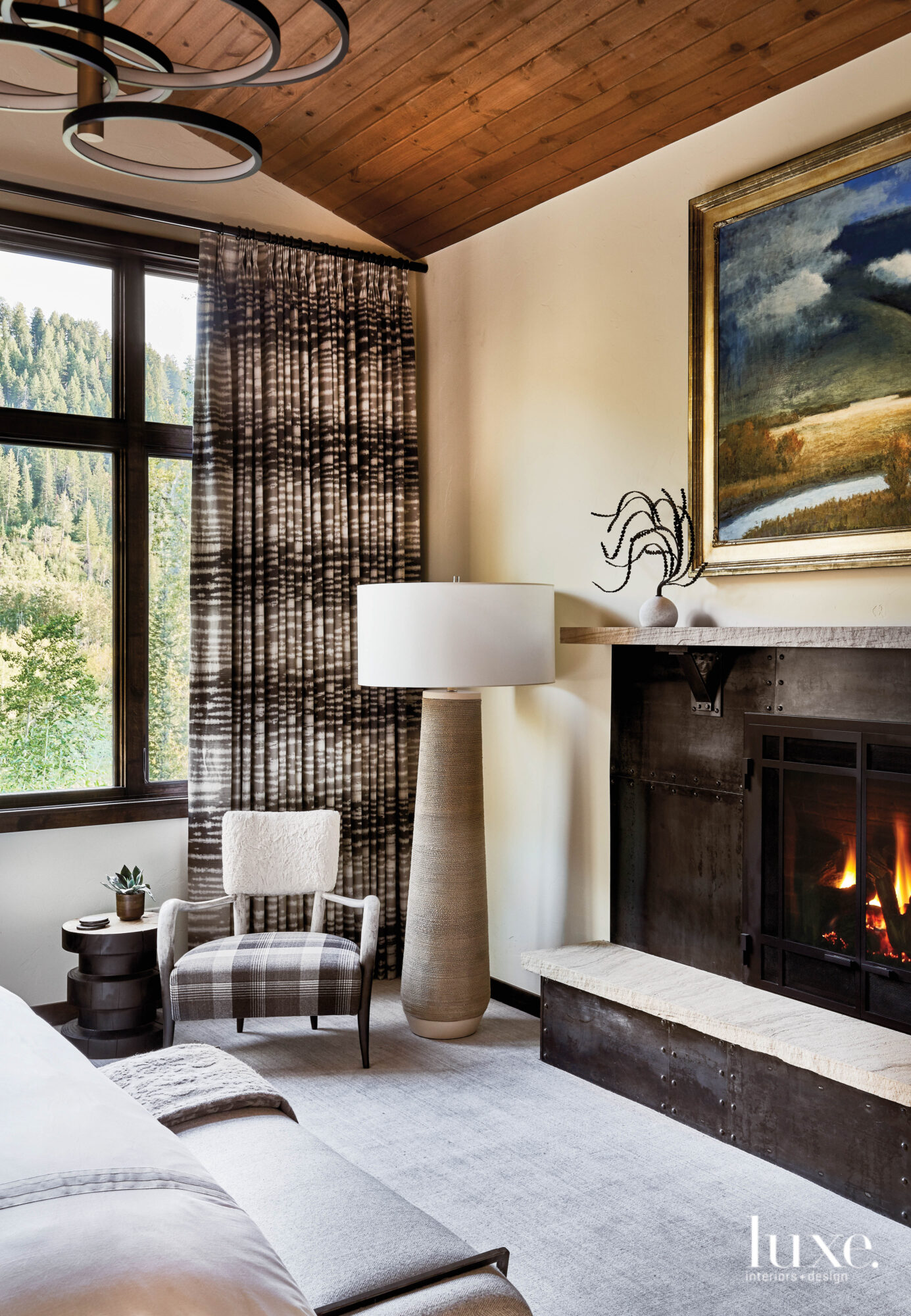 The master suite has a large fireplace and a cozy armchair.