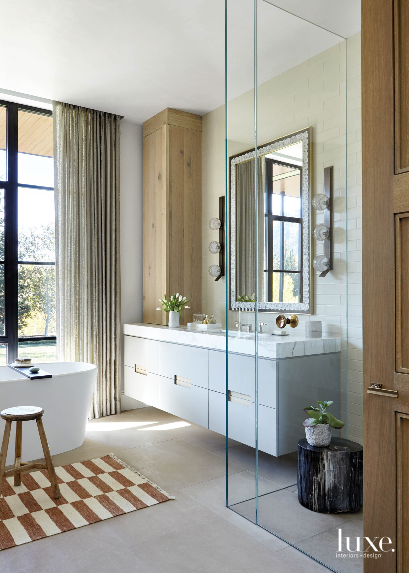 The primary bathroom has a large, glass-sided shower and a floating vanity.