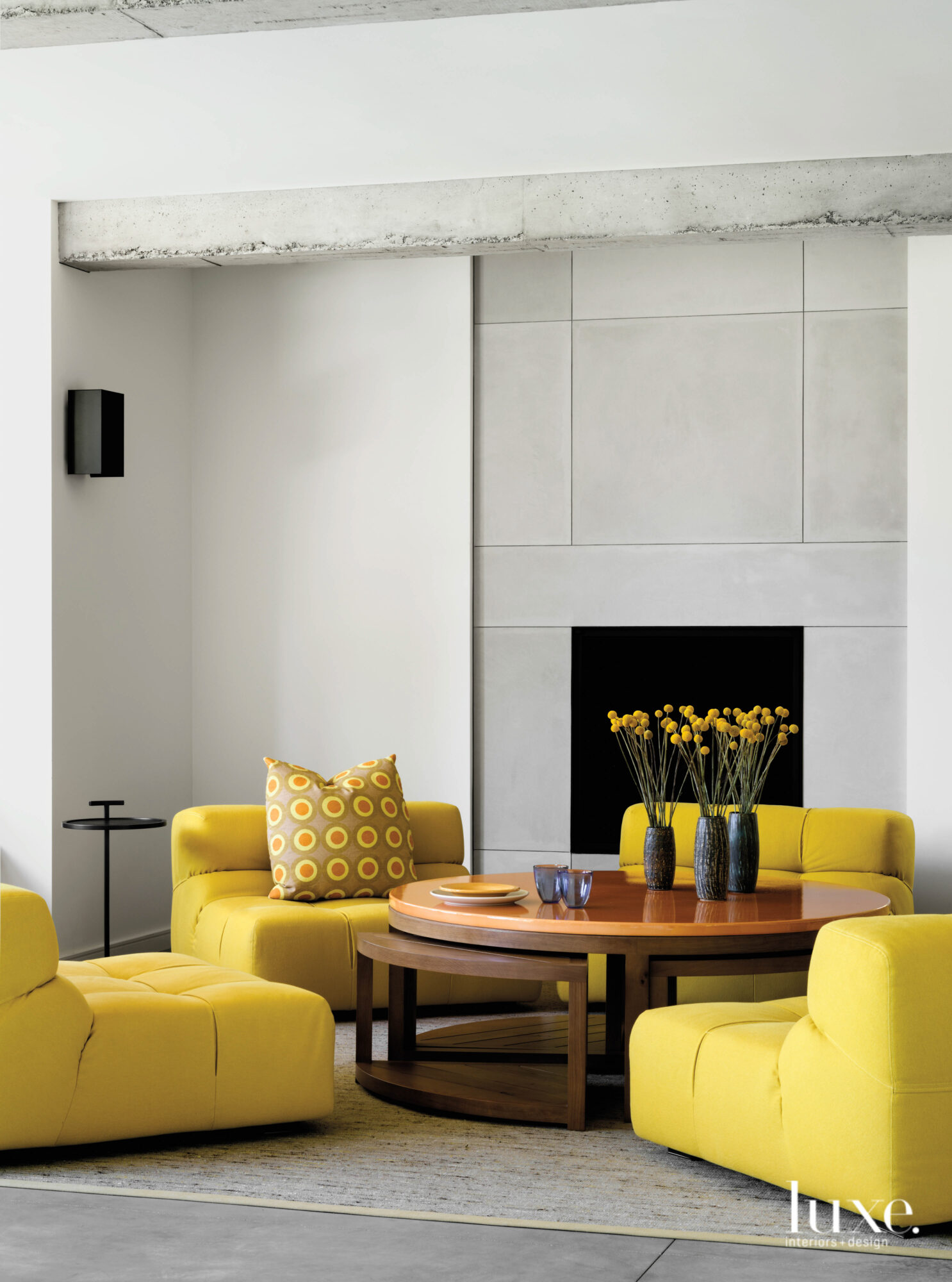 The recreation room has four yellow chairs gathered around a circular table near the fireplace.