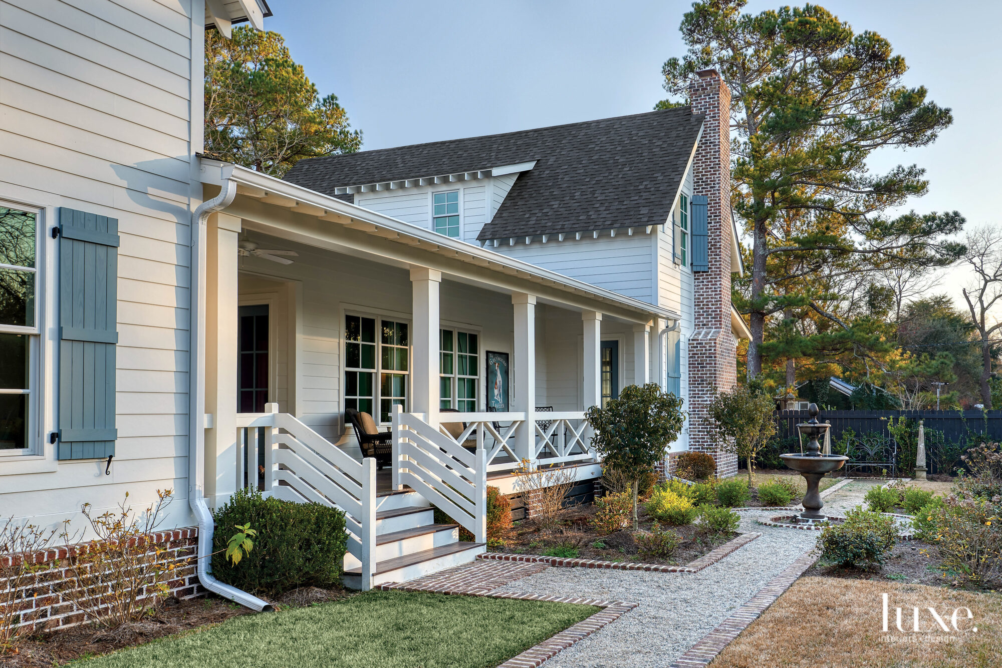 House exterior, porch, garden paths, sky and pine trees